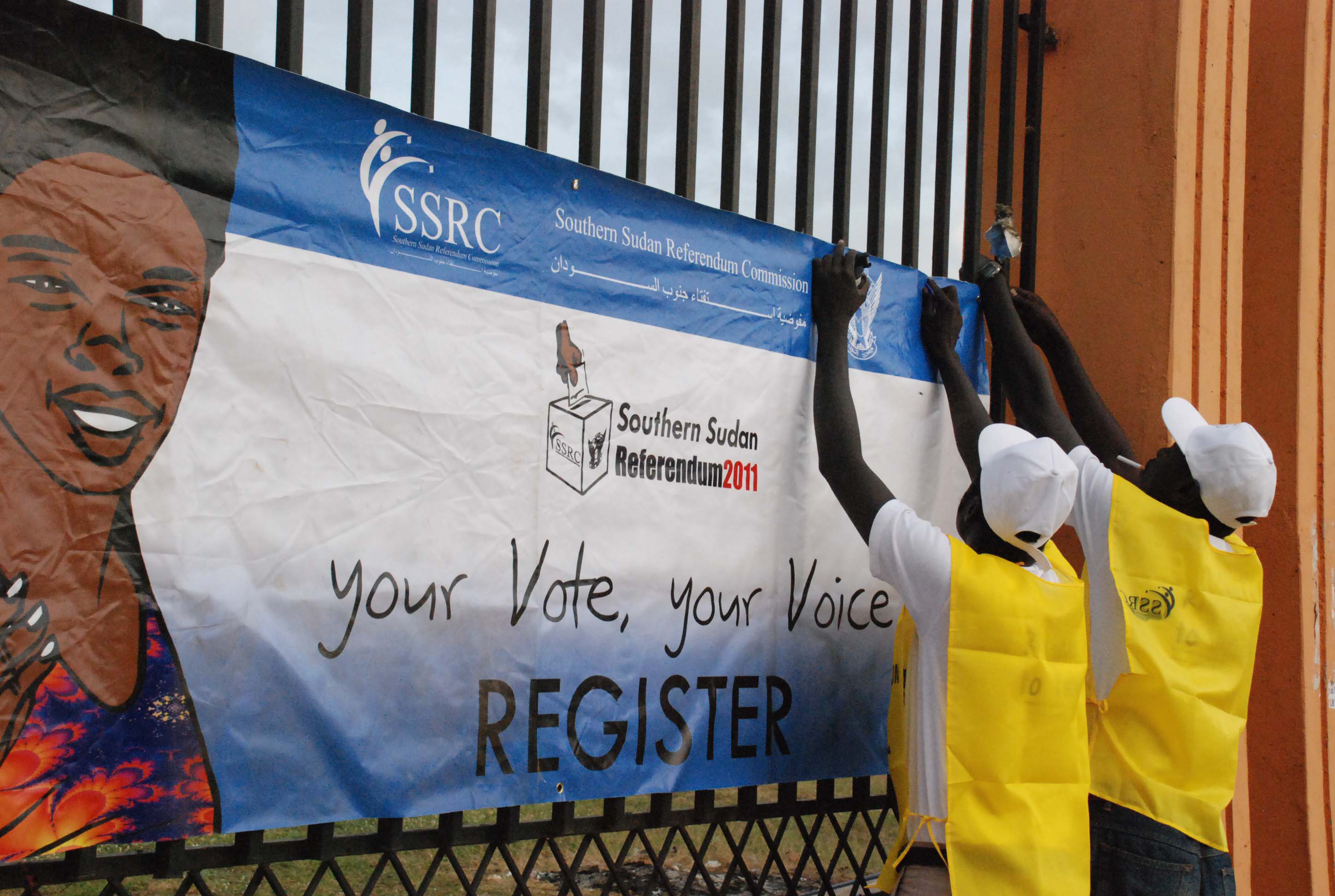 Officials from the South Sudan Referendum Commission hang posters in the southern capital Juba to encourage people to register for a 9 January ballot that is likely to lead to the secession of Southern Sudan