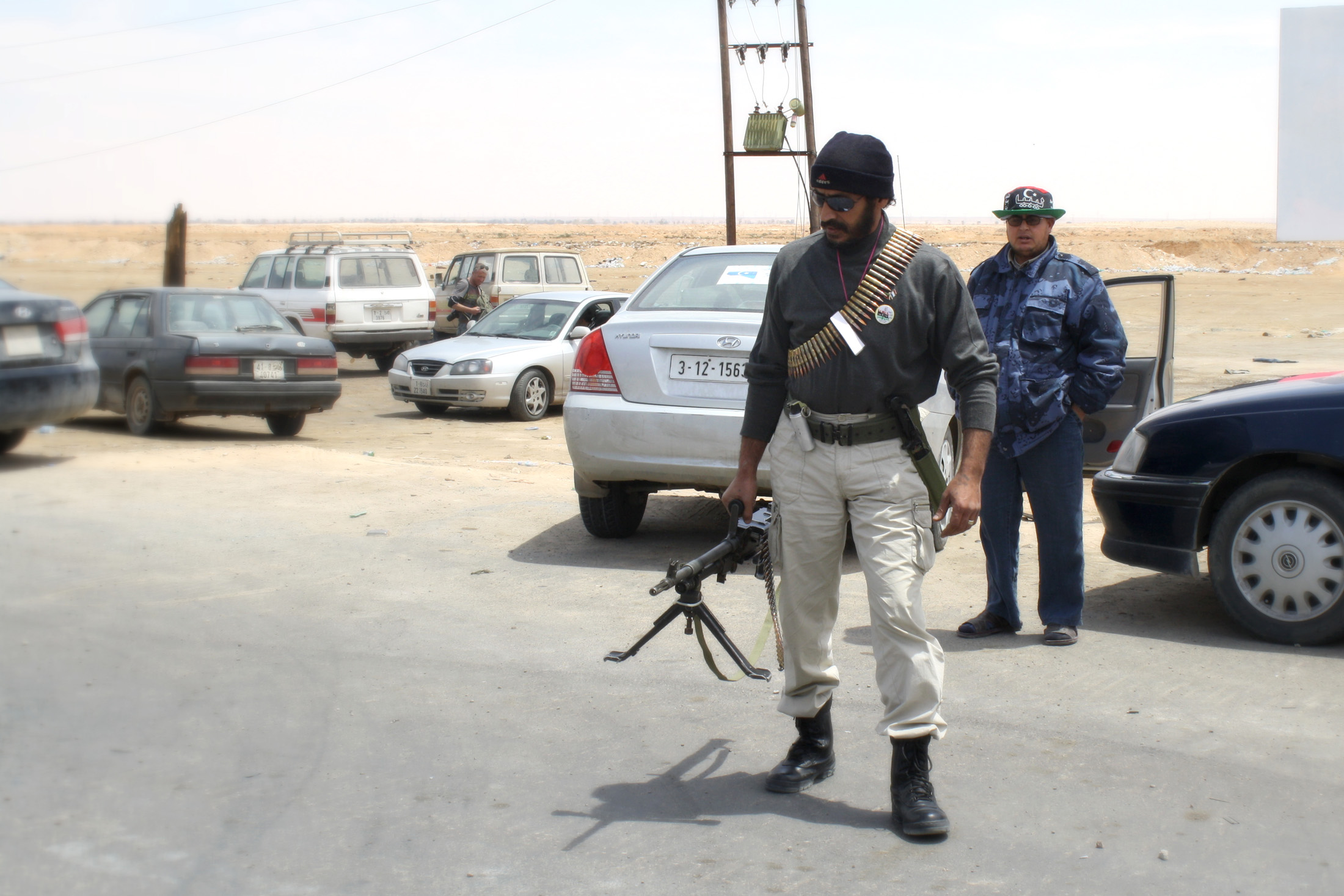 A Libyan rebel fighter arrives by car at the last checkpoint before the frontline, between Ajdabiya and Brega