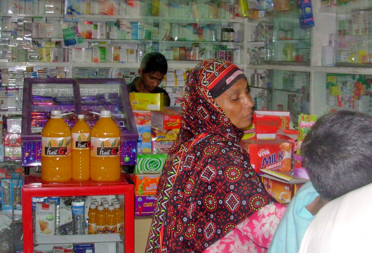 A woman buys drugs at a local pharmacy in Lahore, Pakistan. Many turn to pharmacies to meet drug needs