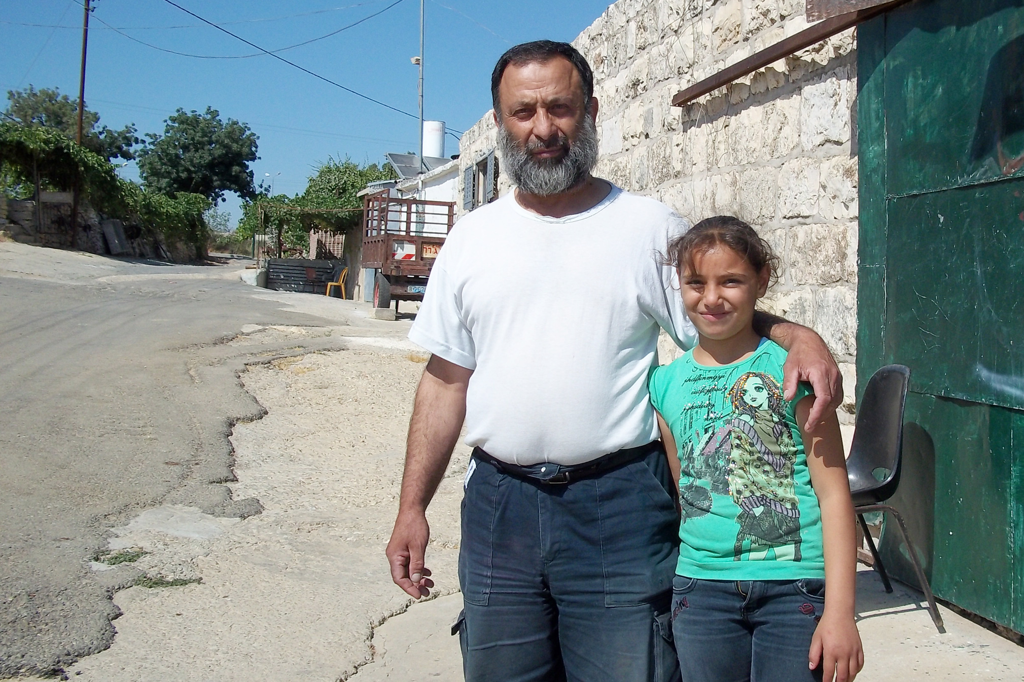 Mohamed Khalil, 55, and his daughter Hiba from Khallet Zakariya, West Bank.  Mohamed says Israeli settlers destroyed about half a hectare of his farmland in June 2011 and spray-painted “death to Arabs” on the wall of his home