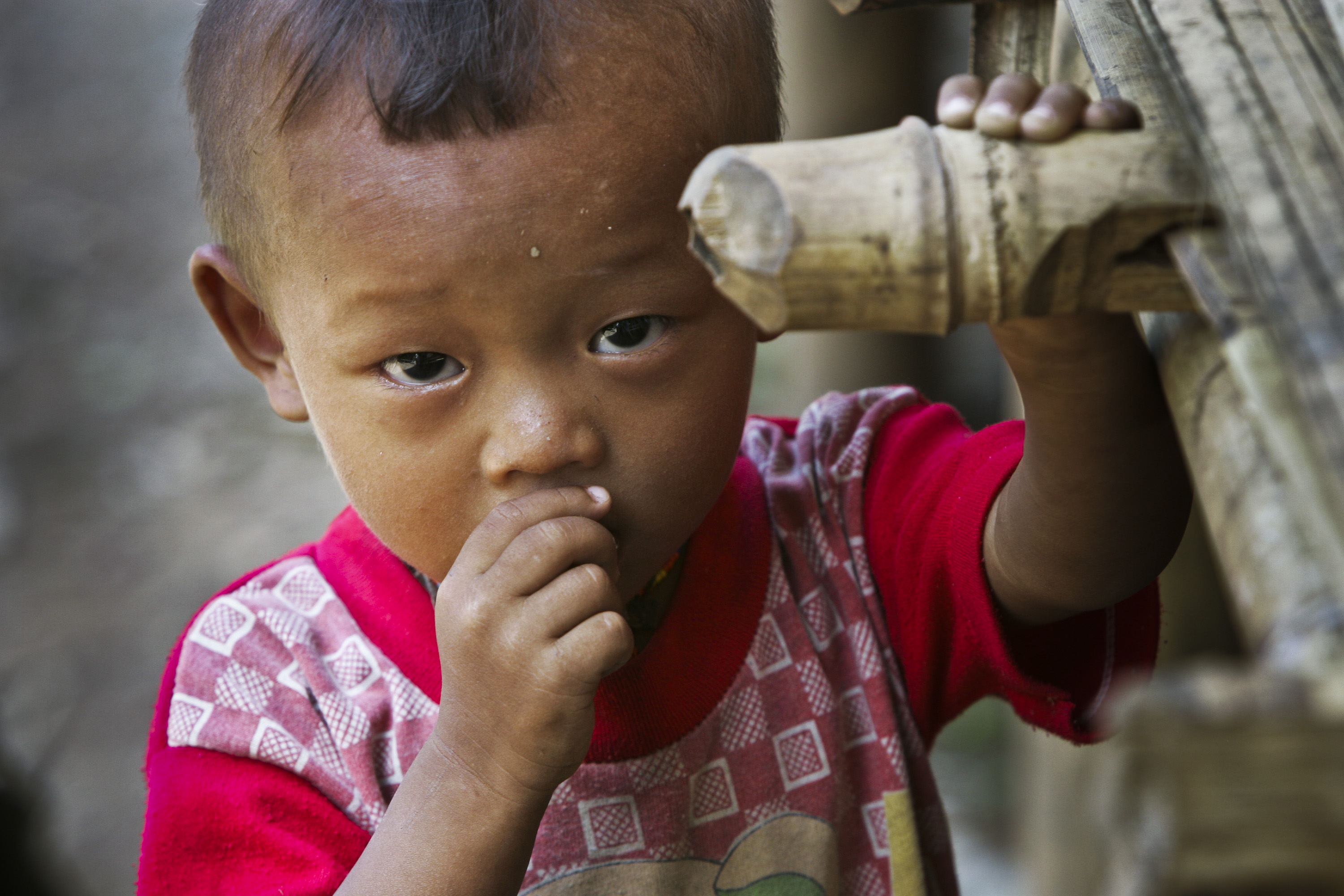 A young ethnic Karen refugee looks up from a newly erected bamboo hut in a displaced persons camp just inside Myanmar along the Myanmar-Thai border. The Karen, who have been involved in a civil war against Burmese government since 1946, continue to resist