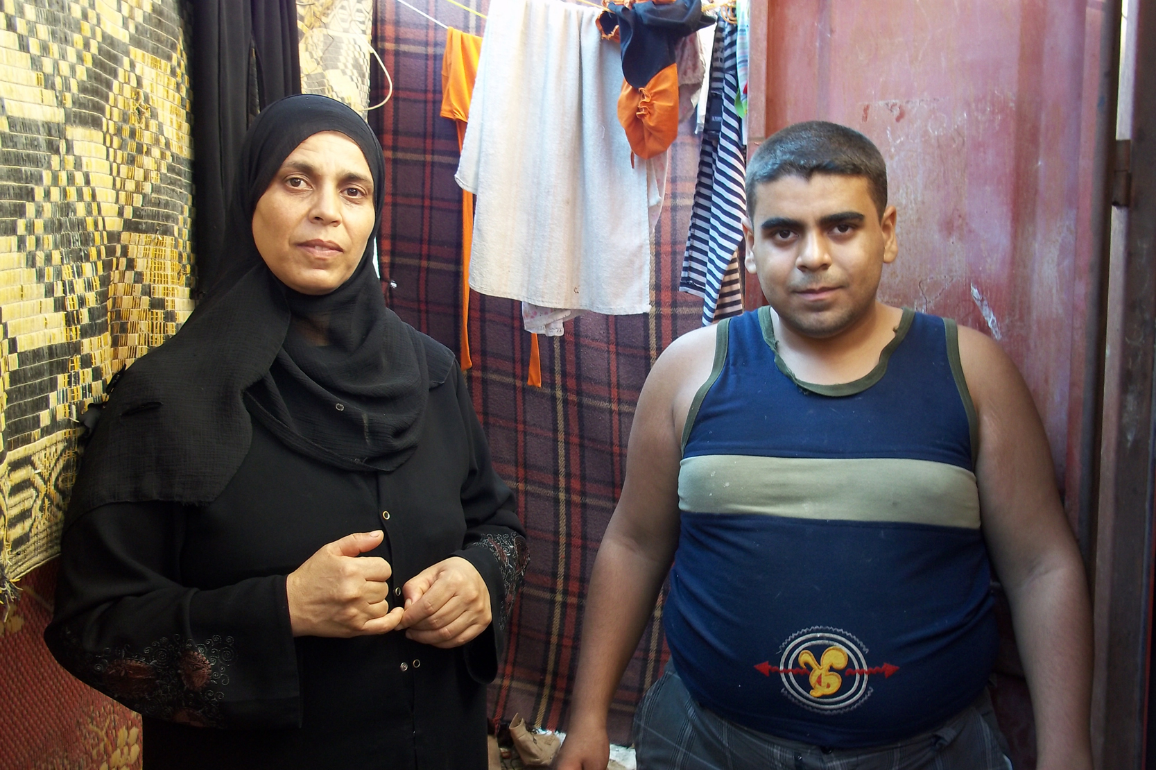 Shahrazad AbuThuria, 41-years old from Gaza City, and her 16-year old son Belal, who is mentally disabled. She and her six children live in a two-room garage without insulation.  As a refugee Shahrazad receives food assistance from the UN Relief and Works