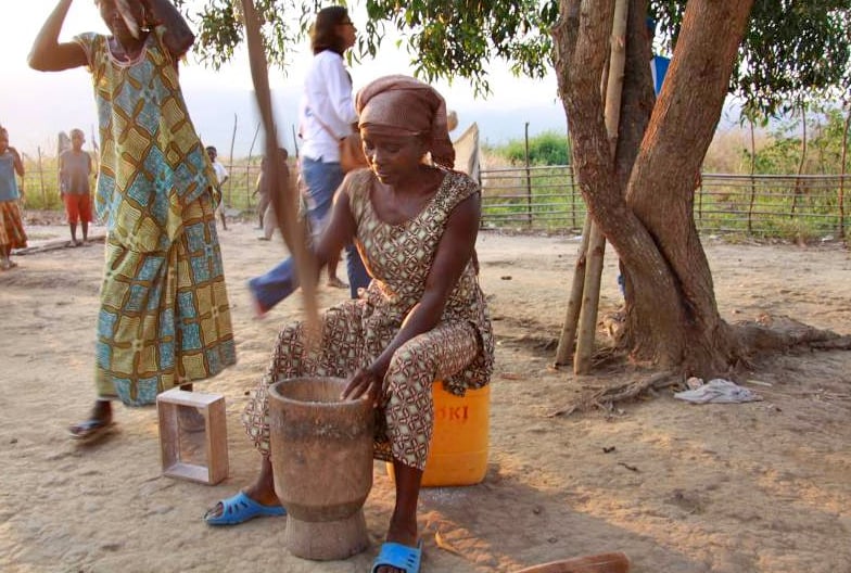 Angolan refugee Maria, 50, pounds manioc for the family dinner in Kilueka refugee settlement, DRC