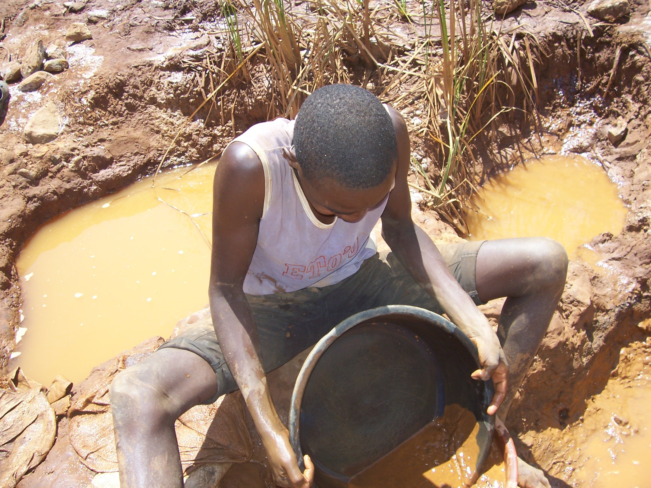 A young man pans gold dust at a mine in western Kenya