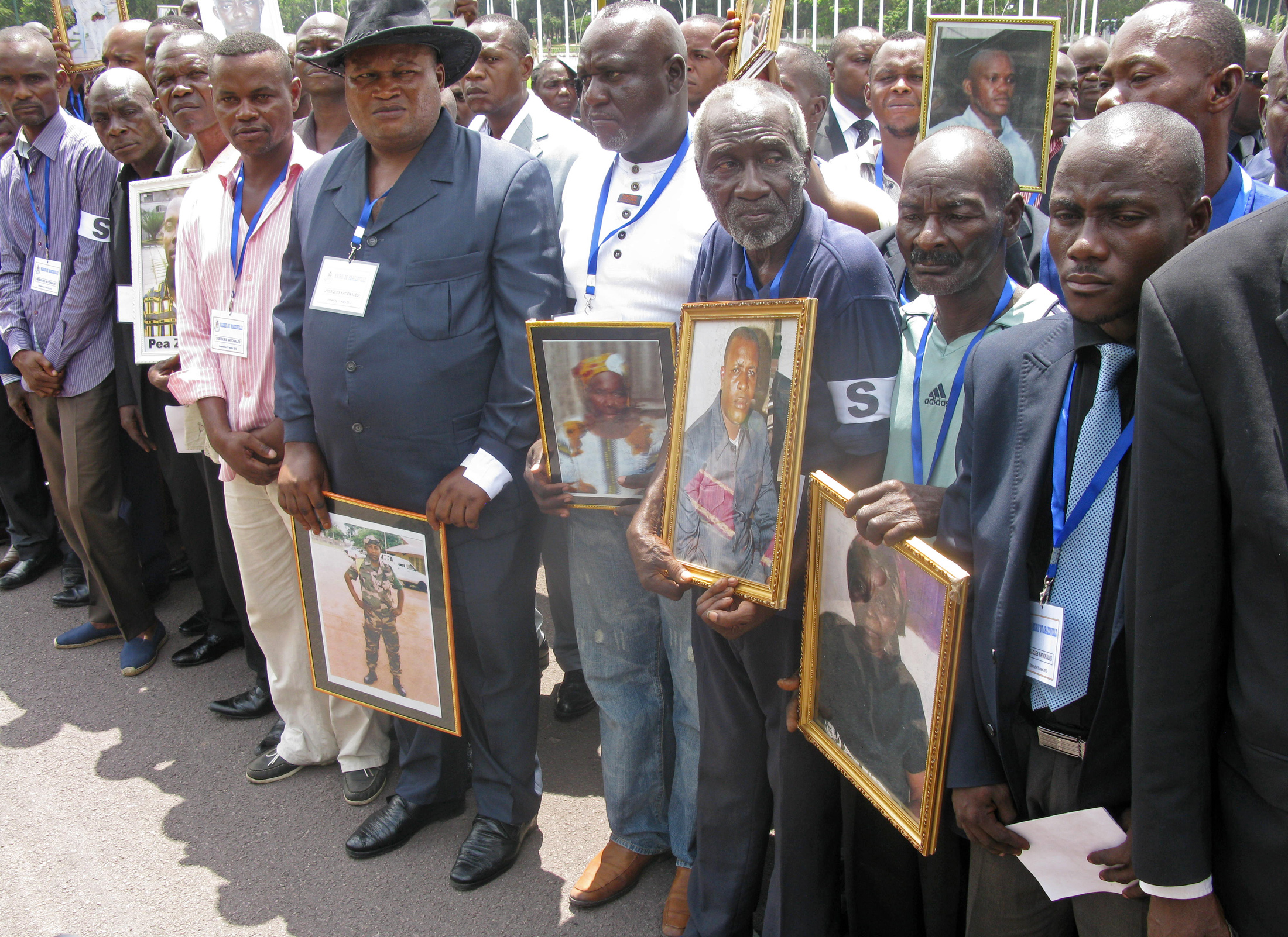 Relatives hold images of departed loved ones at a memorial service for victims of a huge munitions blast on 4 March 2012 in Brazzaville