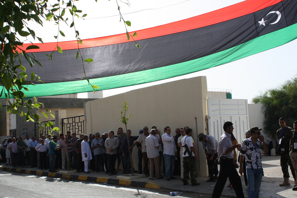 Voters queue by a school gate to vote in Sunday's Libyan Elections