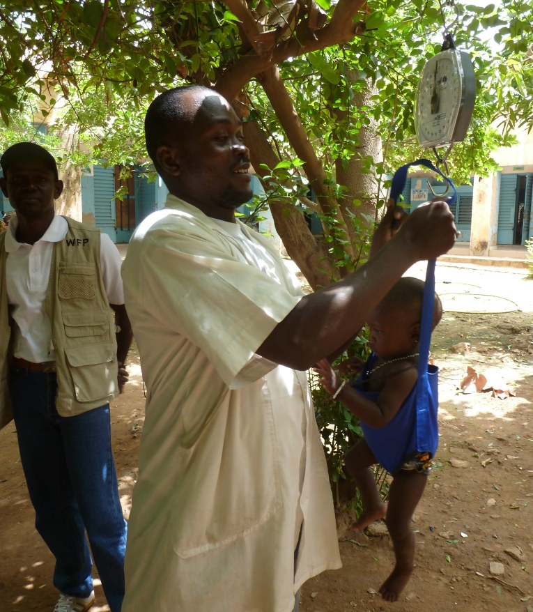 A doctor at Mopti reference hospital weighs a baby thought to be malnourished. While food insecurity and conflict are thought to have worsened malnutrition rates this year, they are always high in Mali