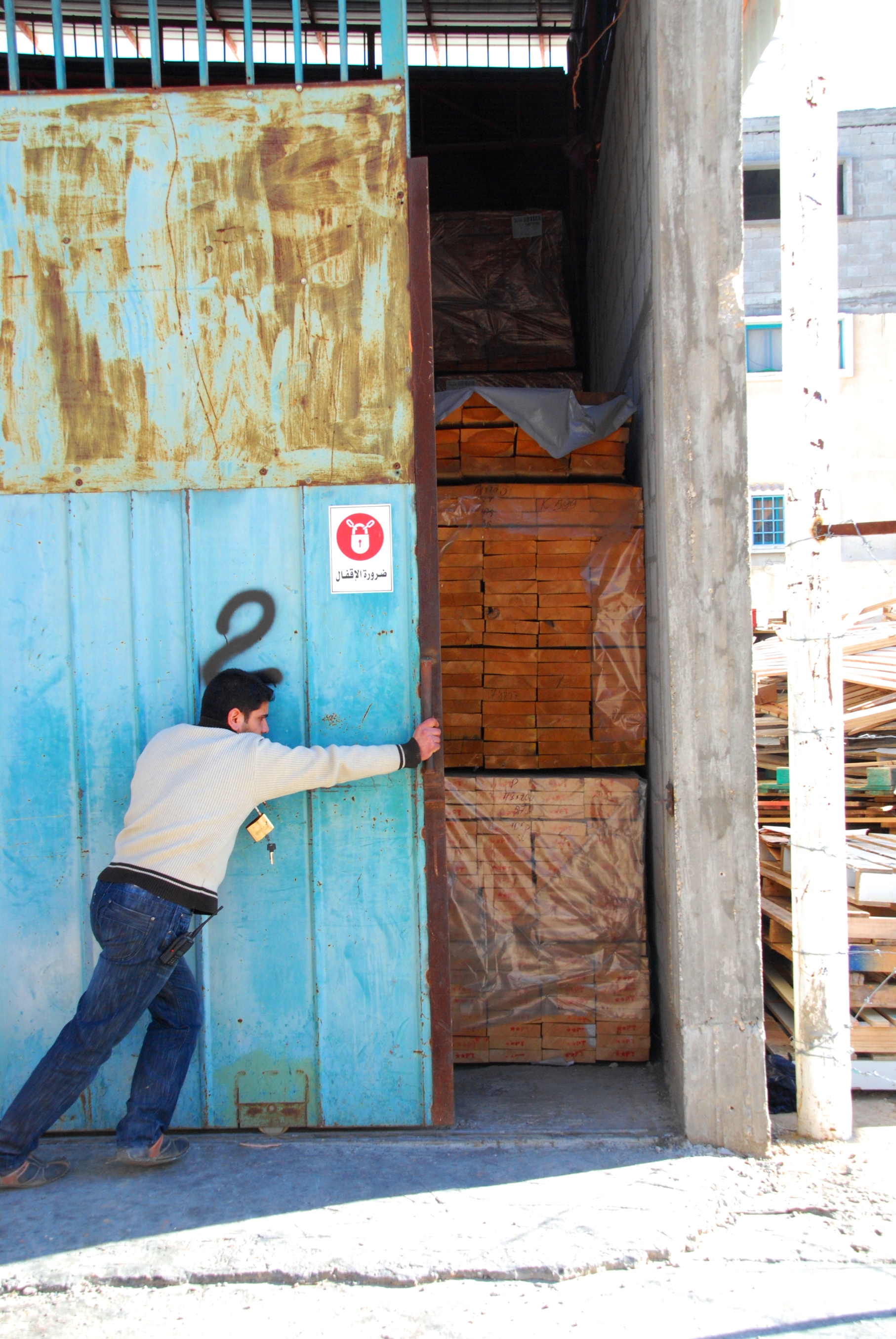 Mu'min Najar opens the door to the goods depot at his father's furniture factory, Modern Industrial Group (MIG) in Gaza. Israeli promises of easier exports out of Gaza have not been fulfilled