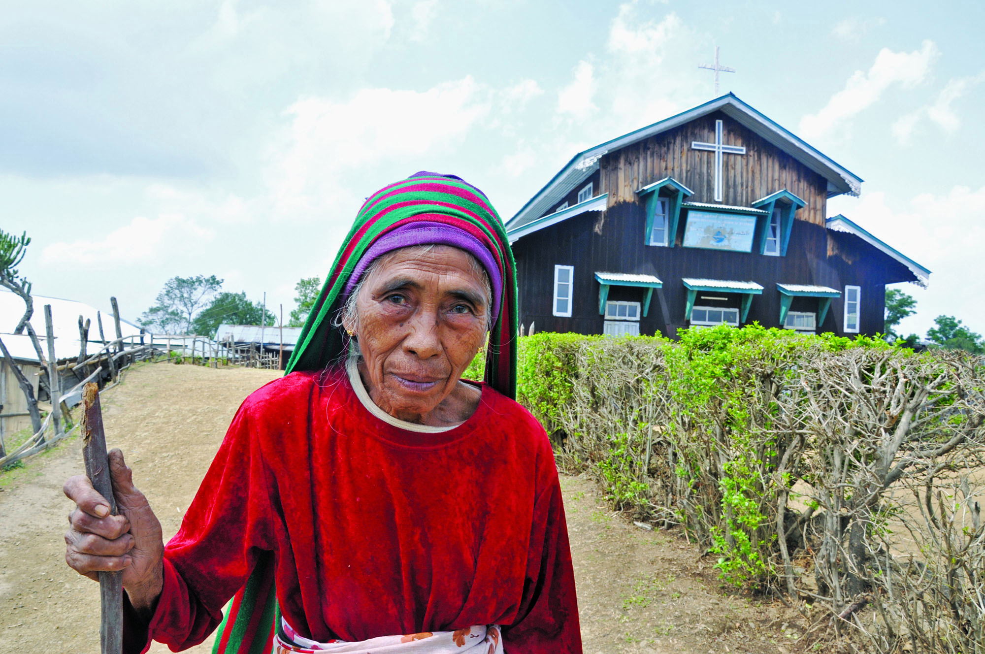 An elderly woman and a church in western Chin State. Approximately 90 percent of all Chin are Christian