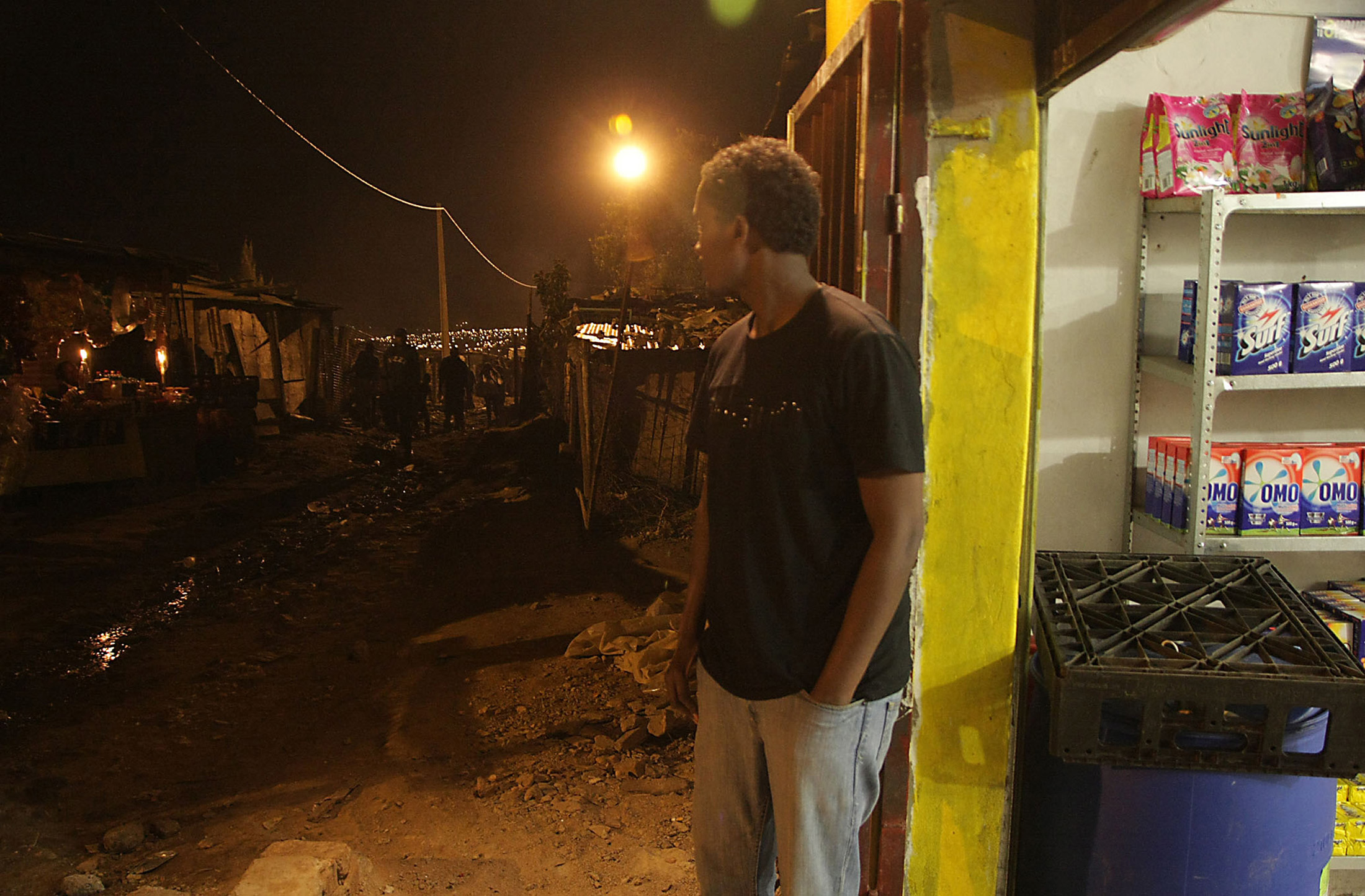 Somali shopkeeper Abdul Abdullah has a generator to light his shop, but most of his neighbours in Zandspruit, an informal settlement near Johannesburg, rely on candlelight