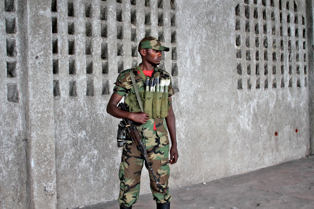 M23 soldier stands guard as M23 rebel spokesman Lt Vianney Kazarama makes a speech in Goma