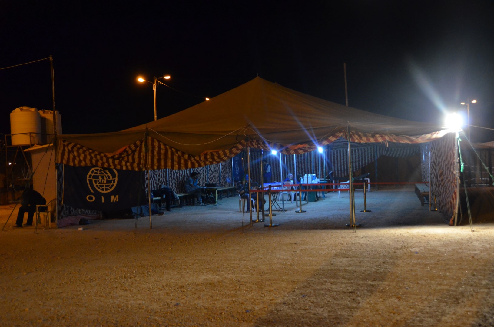 Employees of the International Organization for Migration prepare to receive hundreds of Syrian refugees in the middle of the night at the Za'atari camp in northern Jordan