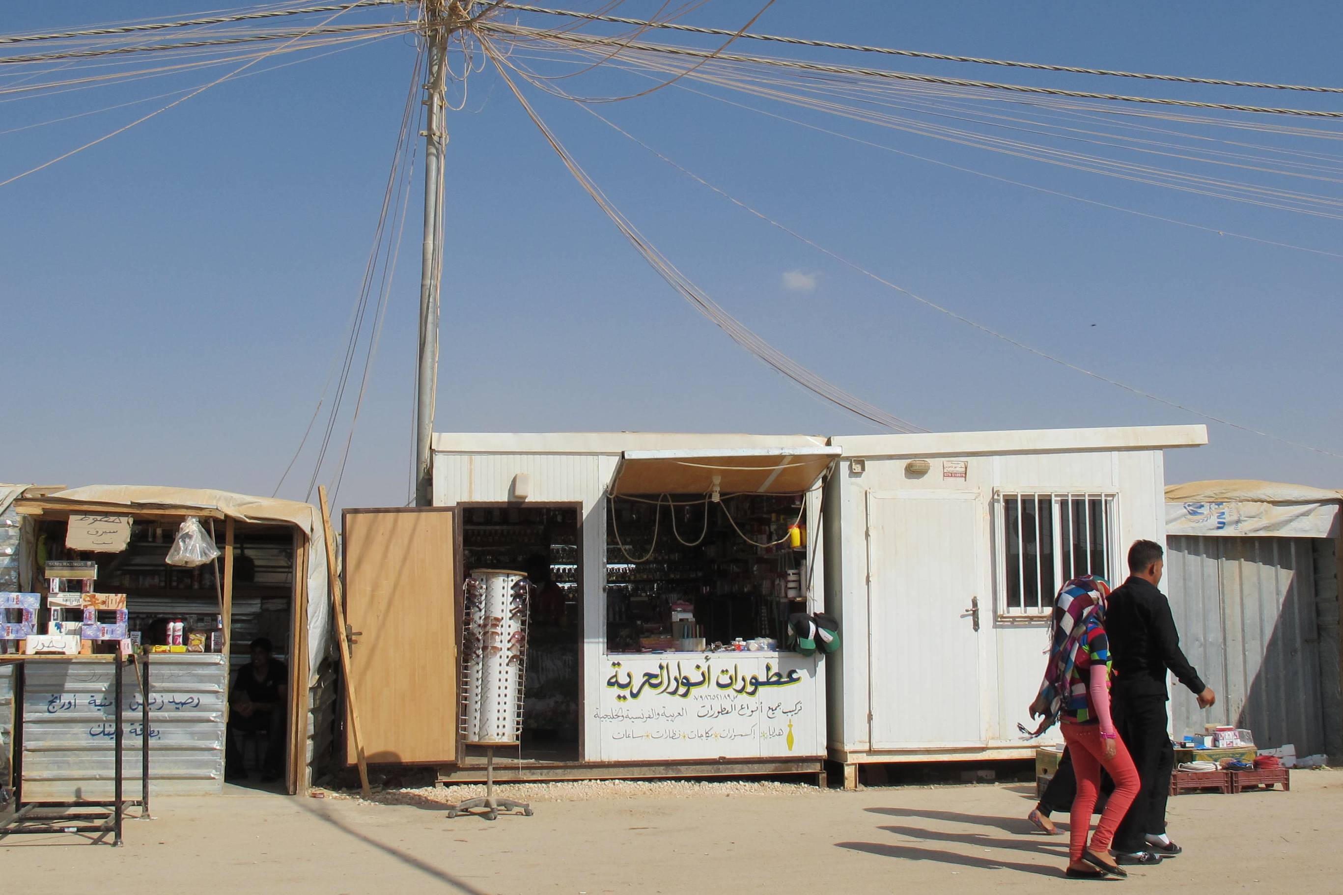 A Syrian refugee in Jordan's Za'atari camp turns his caravan into a shop selling perfumes. A market economy has sprung up in Za'atari camp, now home to some 120,000 Syrians