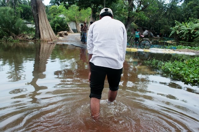 A man wades through an old road in a water-logged village in Satkhira district. Water-logging - prolonged stagnant flooding - continues to impact thousands of residents in southwestern Bangladesh