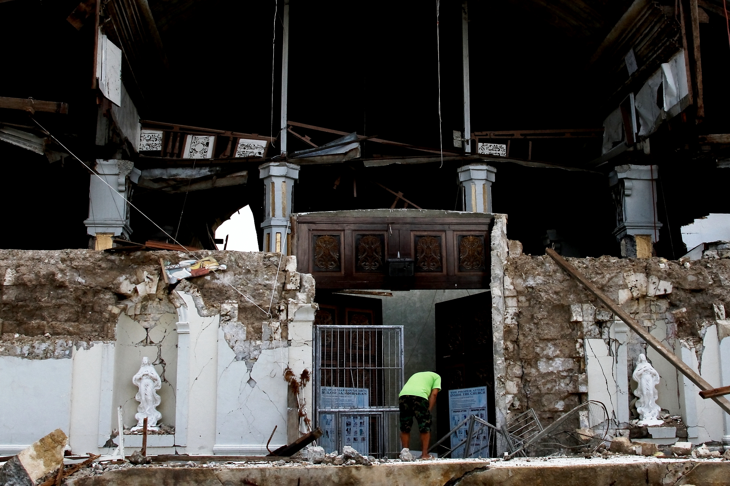 Tubigon, Bohol - A church worker tries to salvage artifacts from a historic church destroyed by the quake