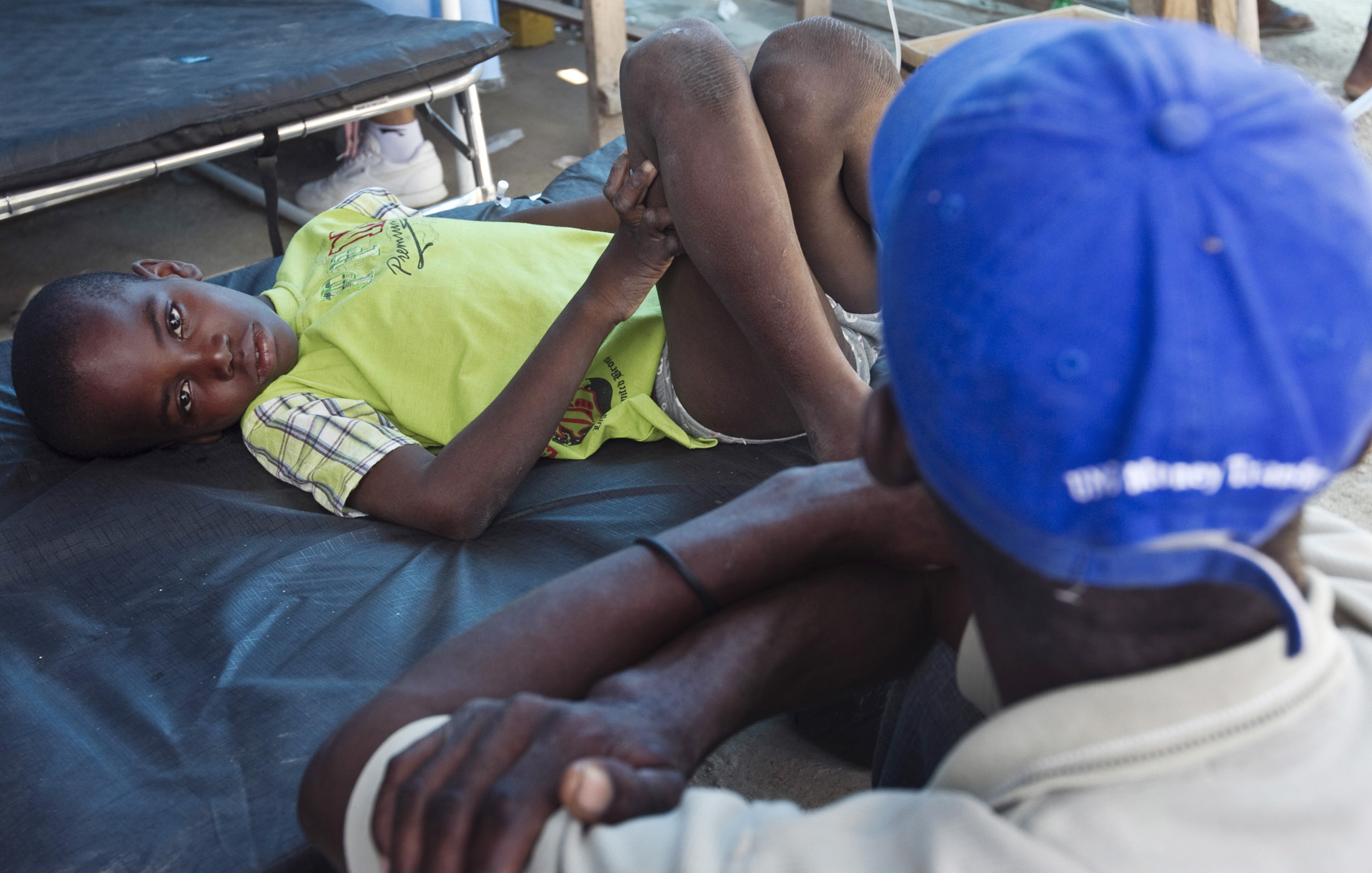 A boy receives treatment for cholera at the hospital in L’Estere, Haiti, as his family watches over him. L’Estere is located in Haiti’s Artibonite region, the centre of the recent cholera outbreak.