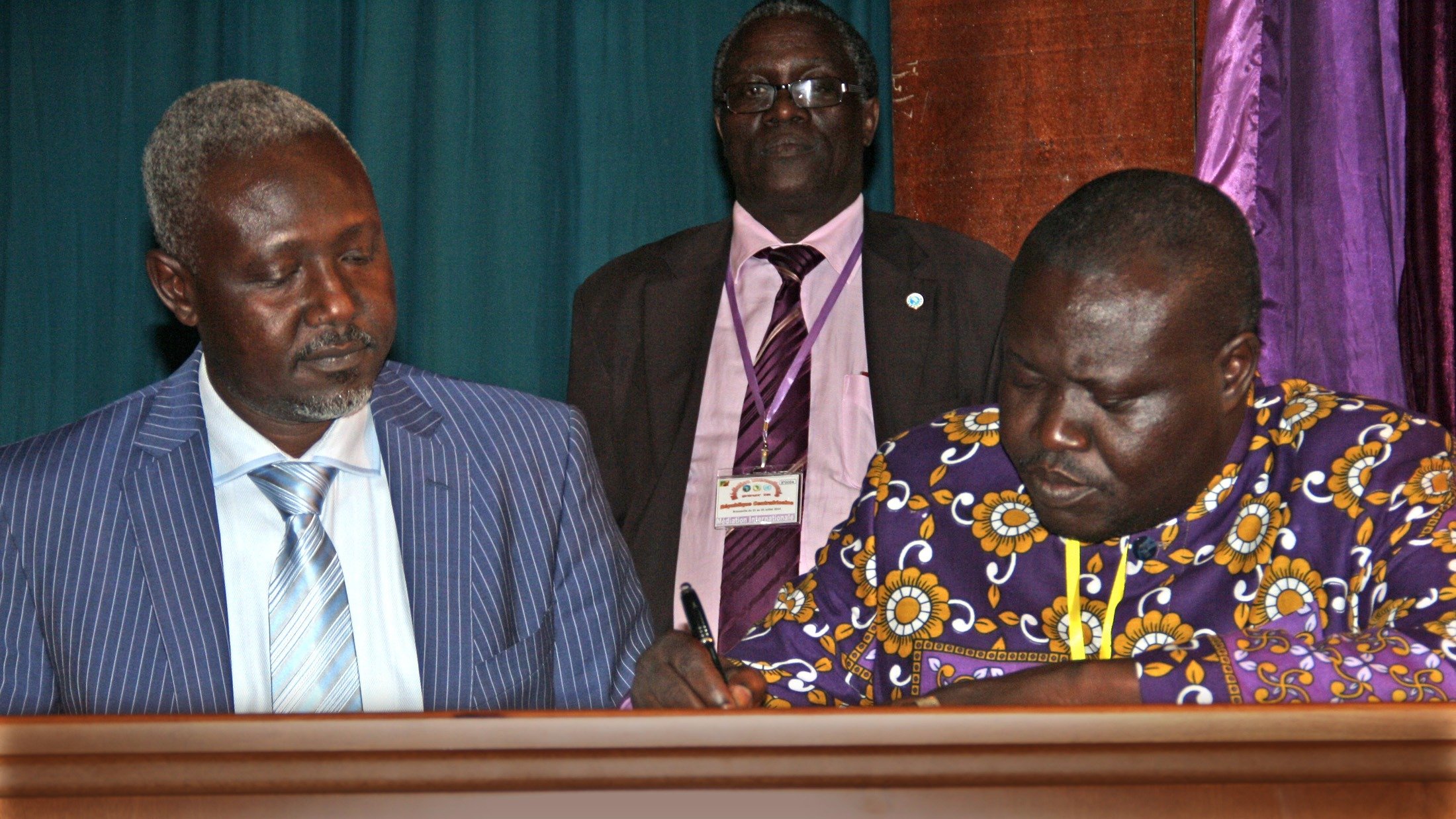 General Mohamed Mousa Dhaffane (left), representative of the ex-Seleka  and Patrice Edouard Ngaissona, representative of the anti-Balaka, signing the CAR cessation of hostilities agreement on 23 July 2014 in Brazzaville. 