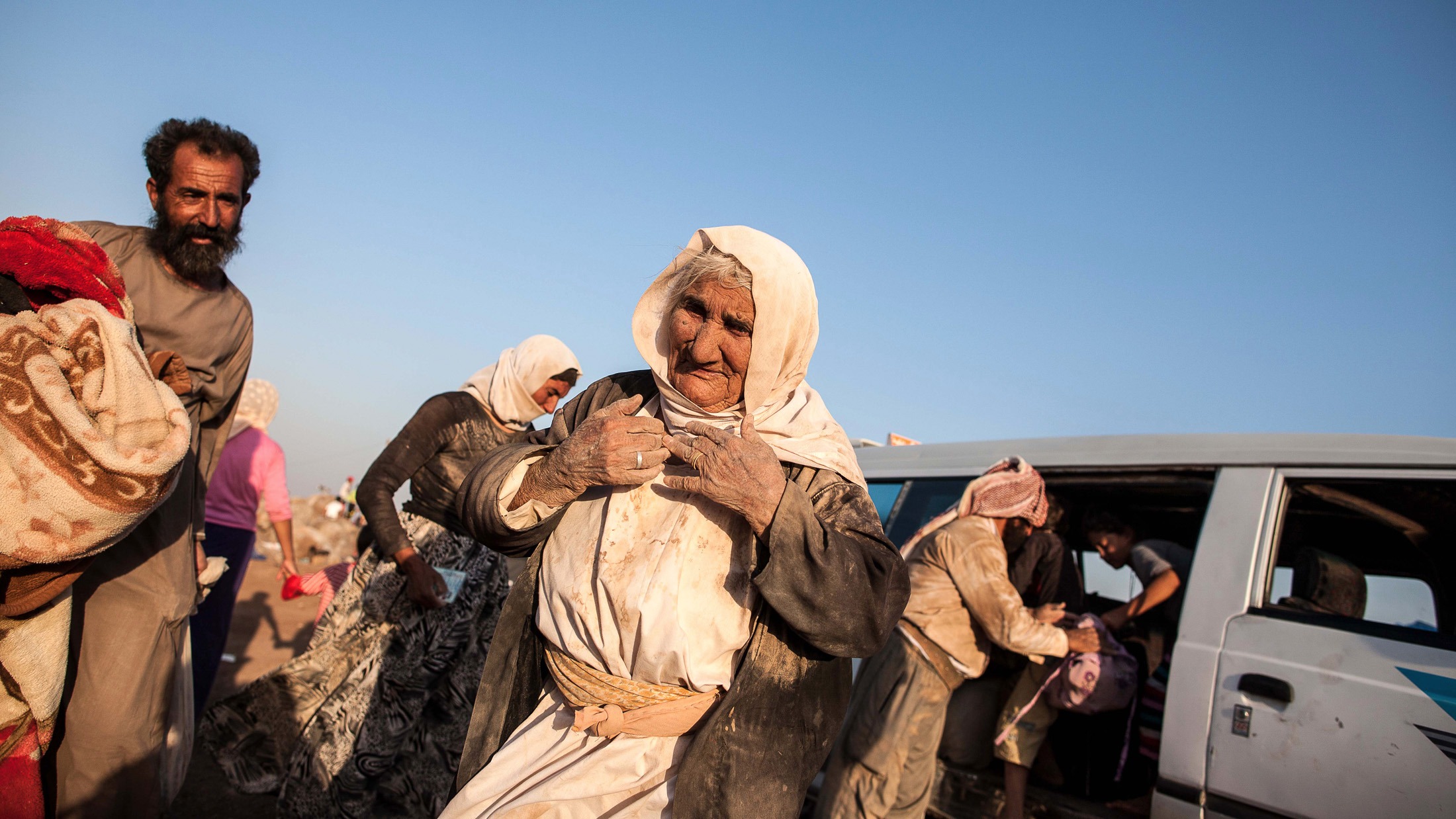 An elderly Yazidi woman arrives with her family into Newroz refugee camp, situated next to the town of al-Malikyah in Rojava, Syria