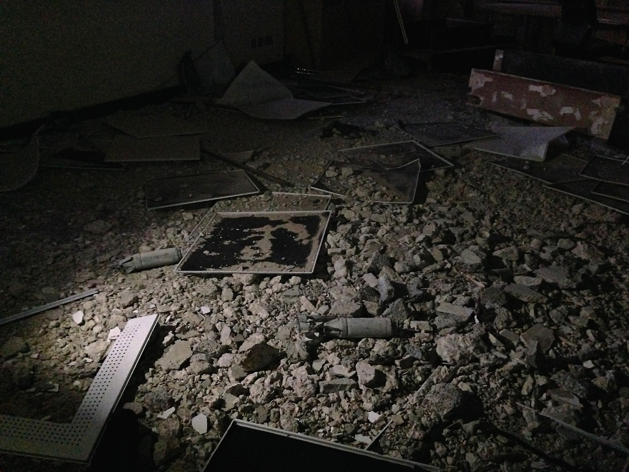 Unexploded ordinance lies scattered on the ground inside the Wahada Bank in Libya. Parts of a large bomb are still lodged in the ceiling, from which smaller missiles tumbled into the foyer of Ben Jawad’s only bank.