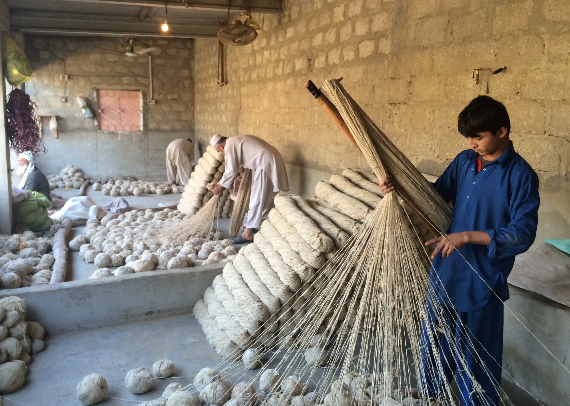 Afghan refugees make rugs by hand in Karachi's Afghan camp on February 1 2015.