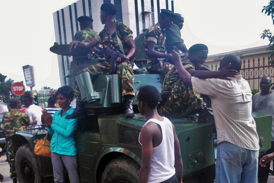 A soldier and civilian embrace in the capital of Burundi, Bujumbura, after Major General Godefroid Niyombare announced the ouster of President Pierre Nkurunziza on 13 May 2015. 