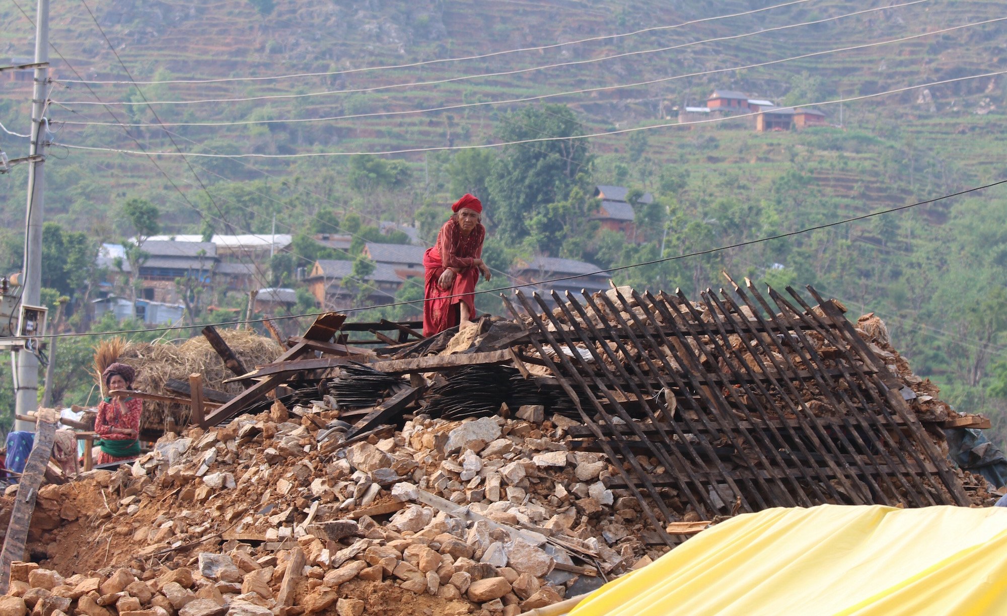 Phulmaya Biswakarma, 70, sits on top of the rubble of what used to be her house in the remote village of Belaune Dara in Nepal's Nuwakot district. Most of the 52 families who live here are in dire need of food aid and shelter