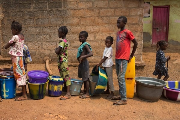 Children queue with containers to receive with water, in the city of Kenema in Kenema District, Sierra Leone.  March 2014