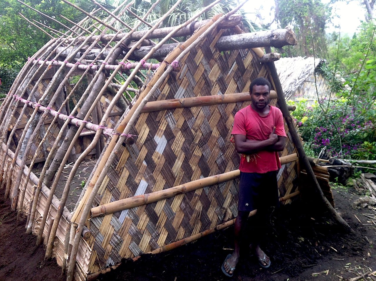 Charlie Kalah stands by a traditional dwelling he is building in his village of Yakel on Tanna Island, Vanuatu, which was devastated by Cyclone Pam in March 2015