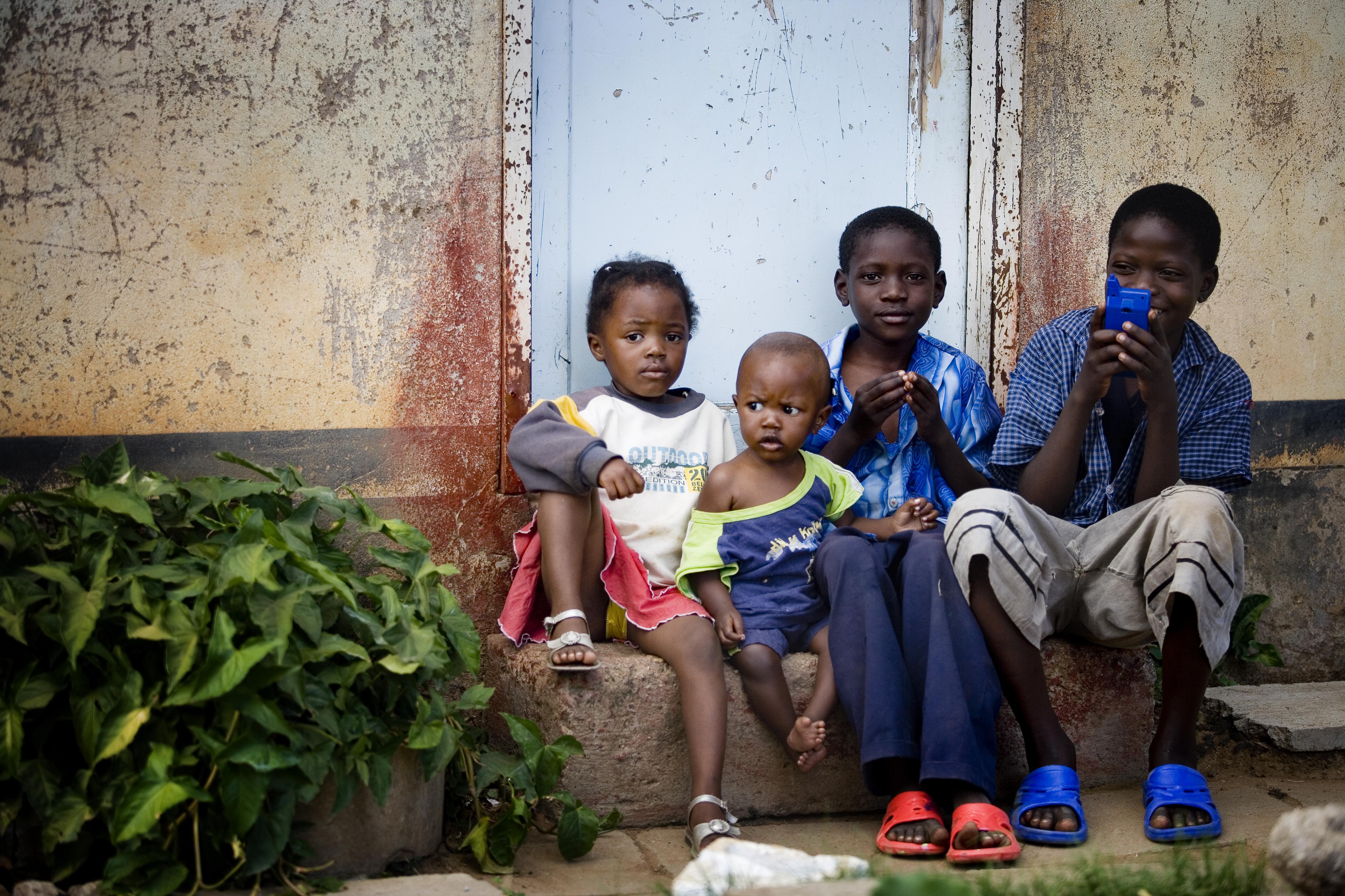 A group of children sit on the step of their families temporary home in Epworth, in Harare, Zimbabwe.