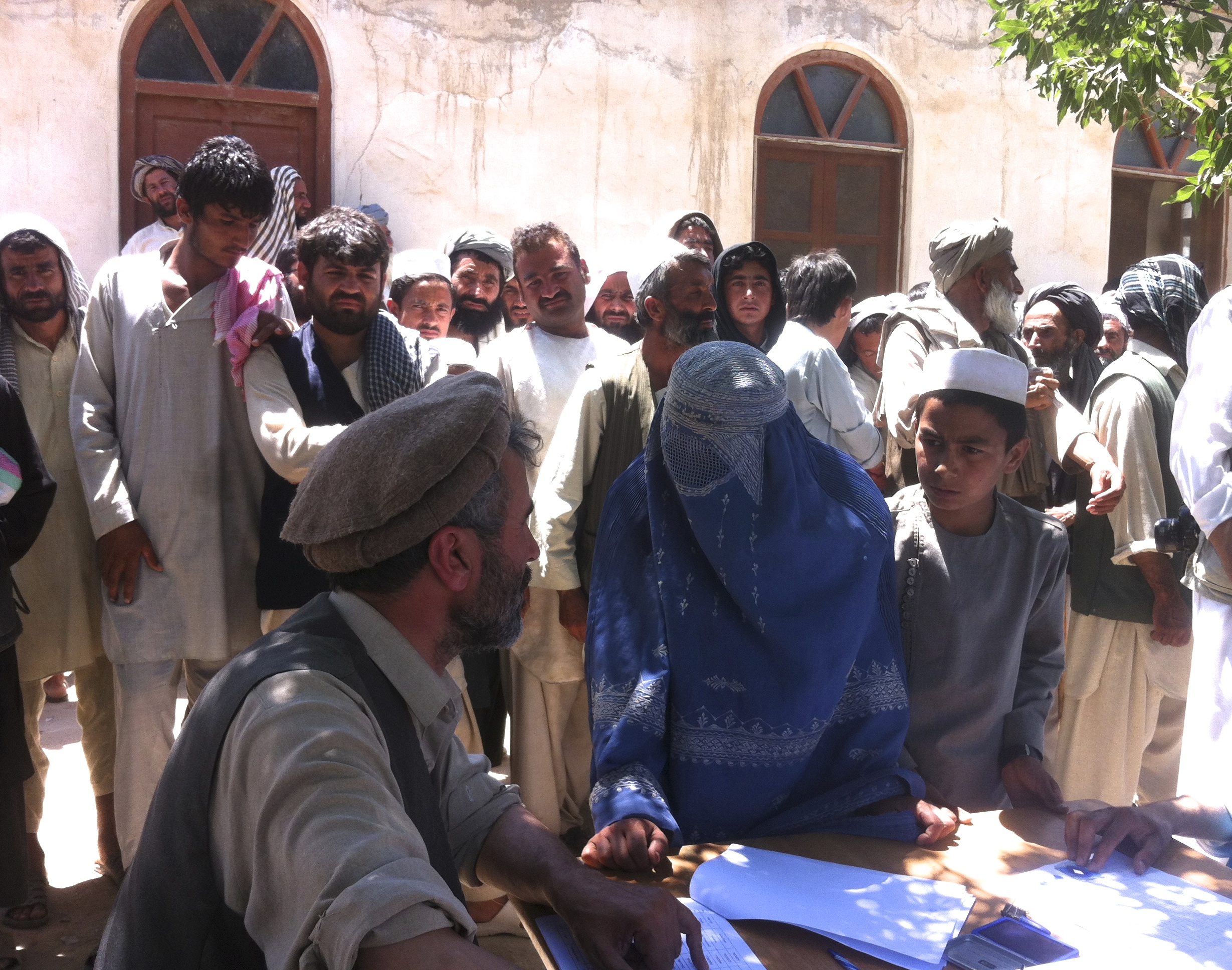 A woman registers her name in order to pick up her aid package in Afghanistan's Kunduz city in April 2015, where she came to escape fighting between the Taliban and government forces.