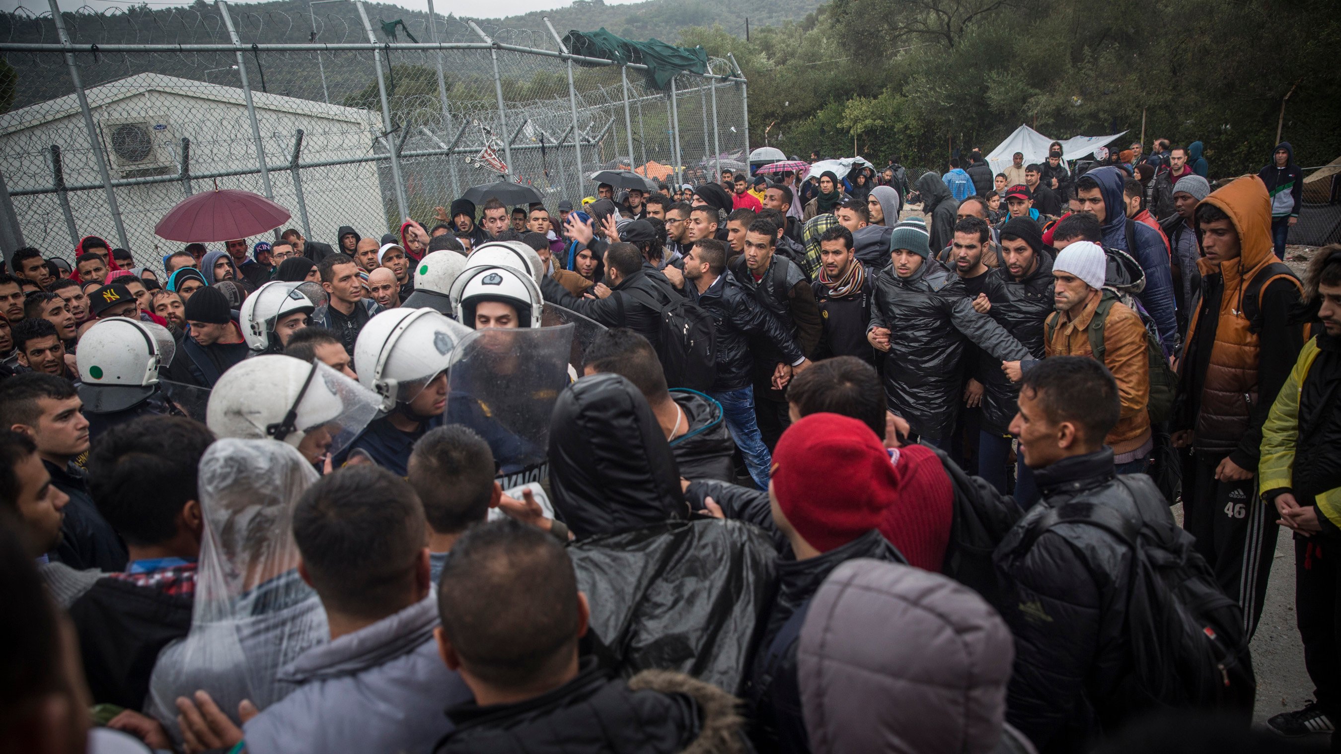 Migrants and refugees wait outside Moria reception centre on the Greek island of Lesvos. A new fingerprinting and screening system has delayed registrations.