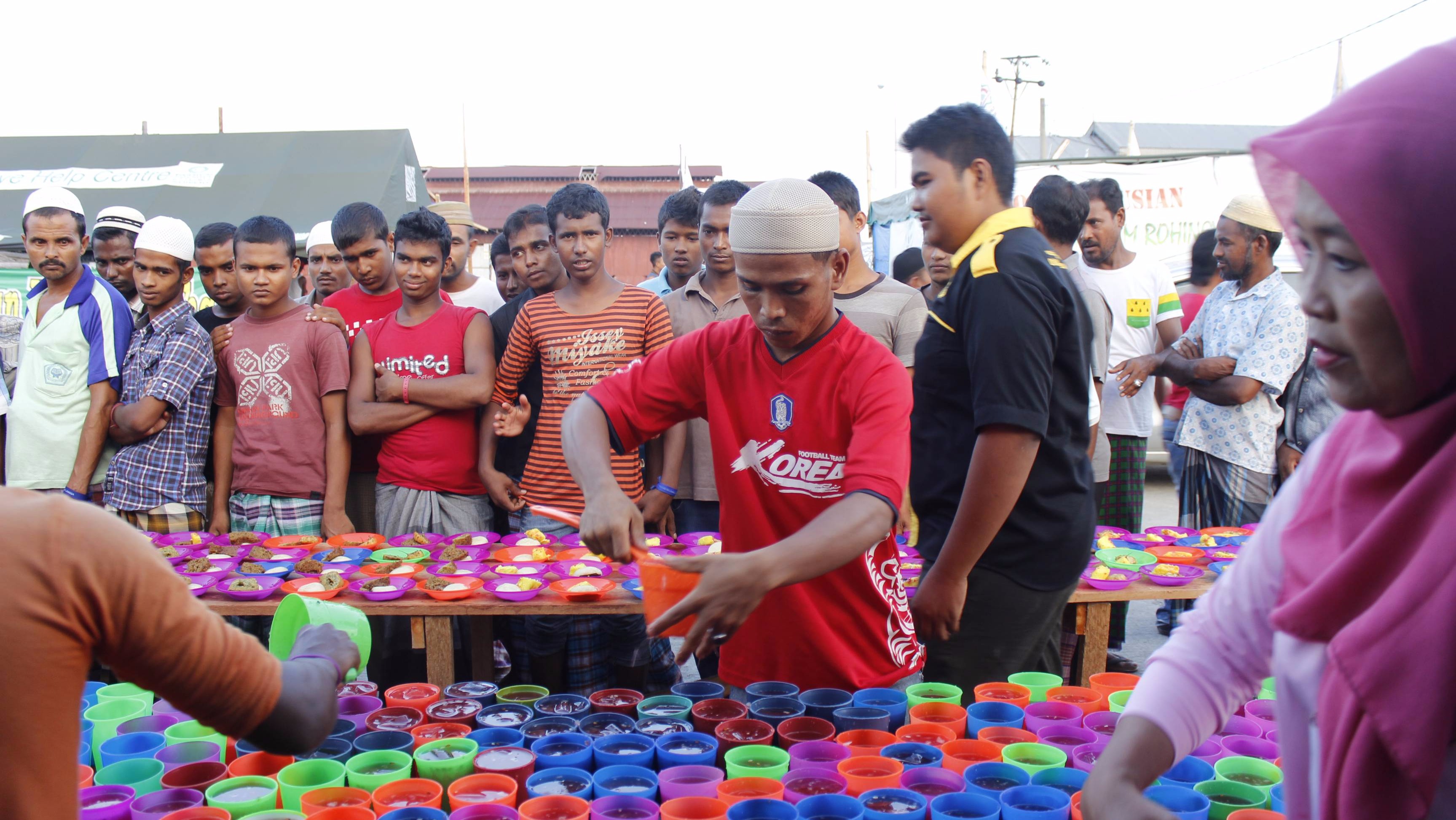 Acehnese fisherman, Karim, who was involved in the rescue of hundreds of Rohingya and Bangladeshi "boat people" in May, serves 'iftar' juice for the breaking of fast during the month of Ramadhan in the temporary refugee camp in Langsa, Aceh.  