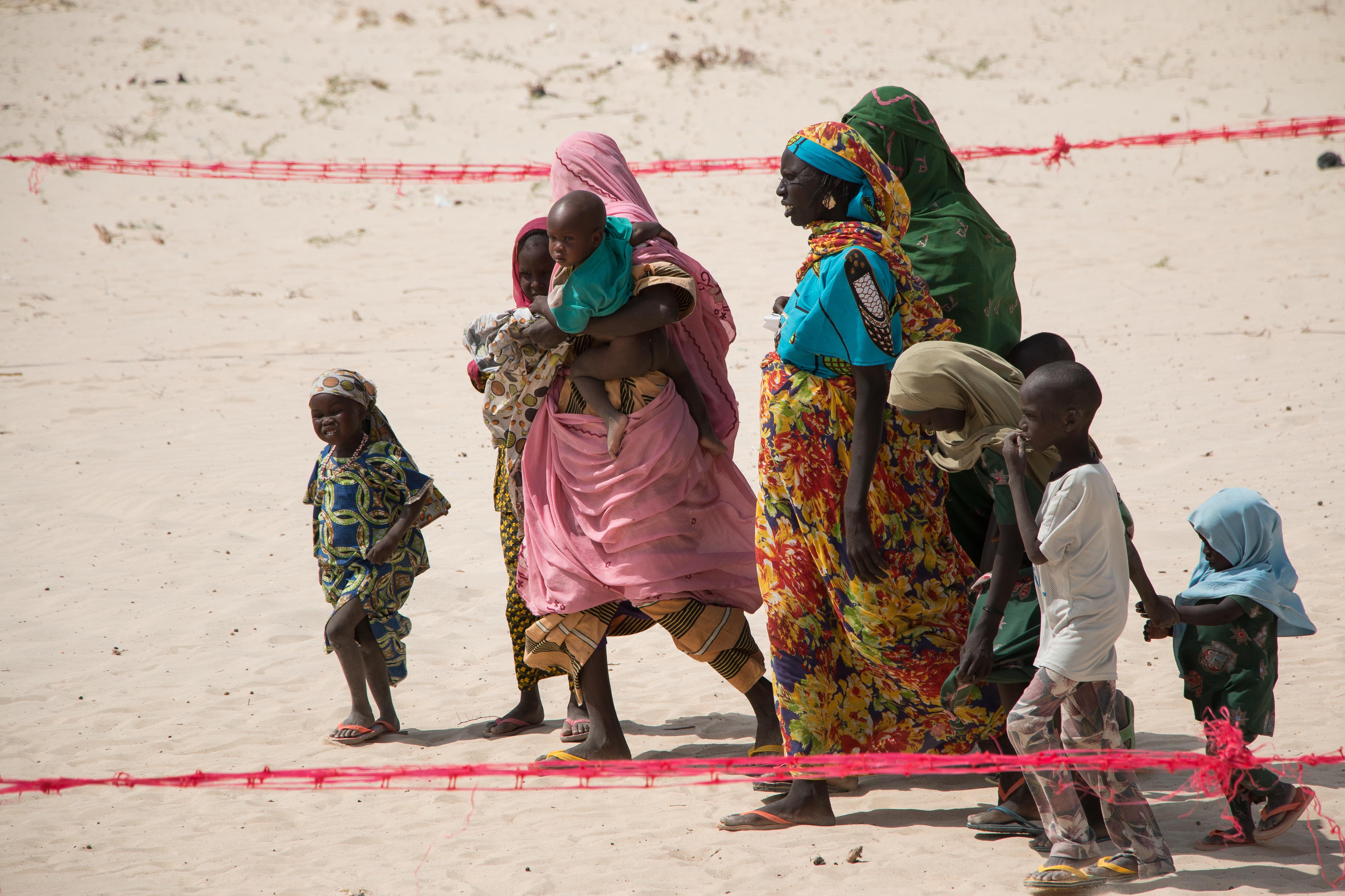 Families gather for another distribution of cash handouts.