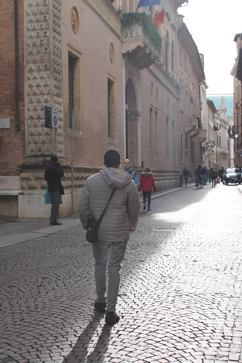 Lamin walks through the cobbled streets of his new home town