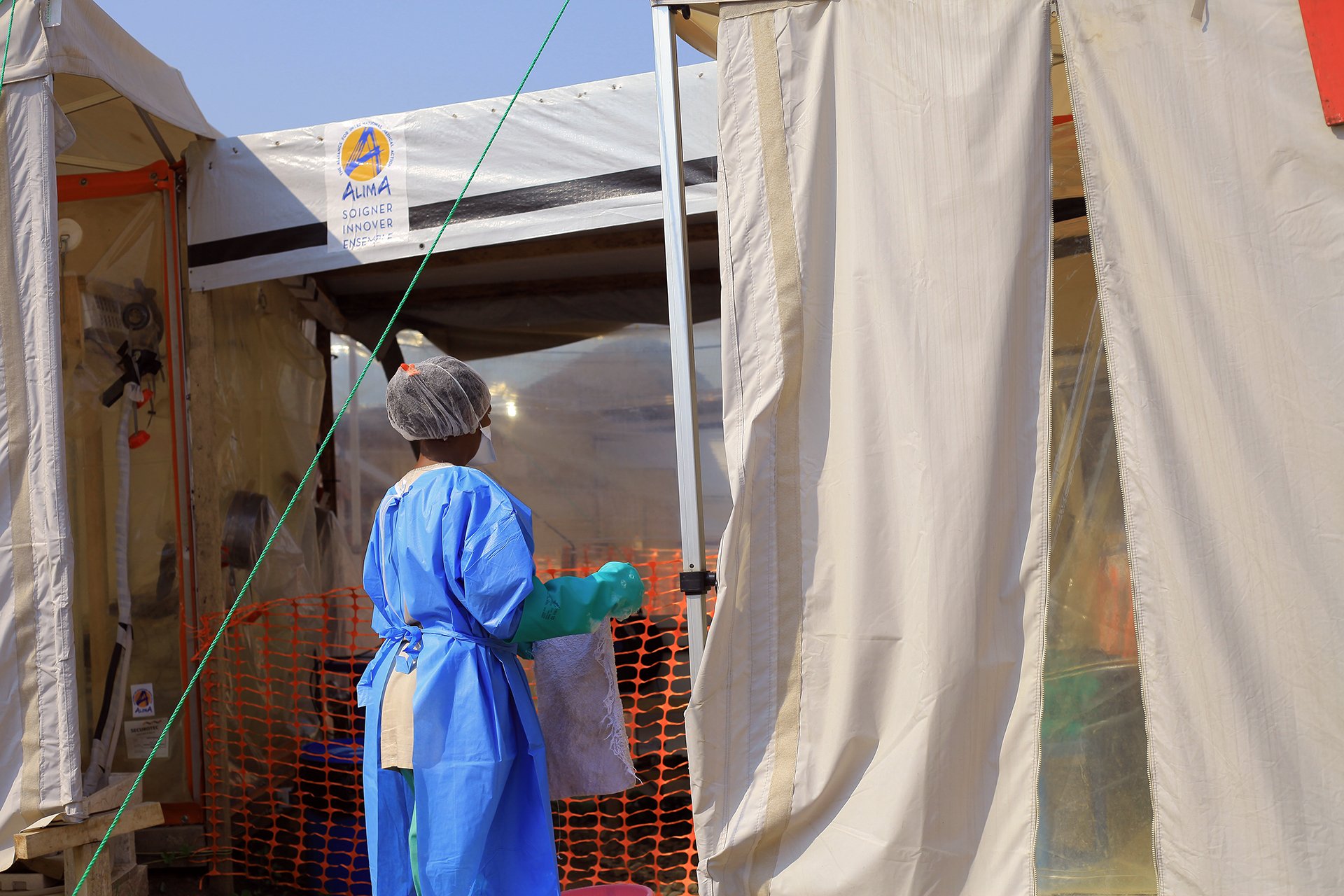 A woman in medical gear outside of a medical tent