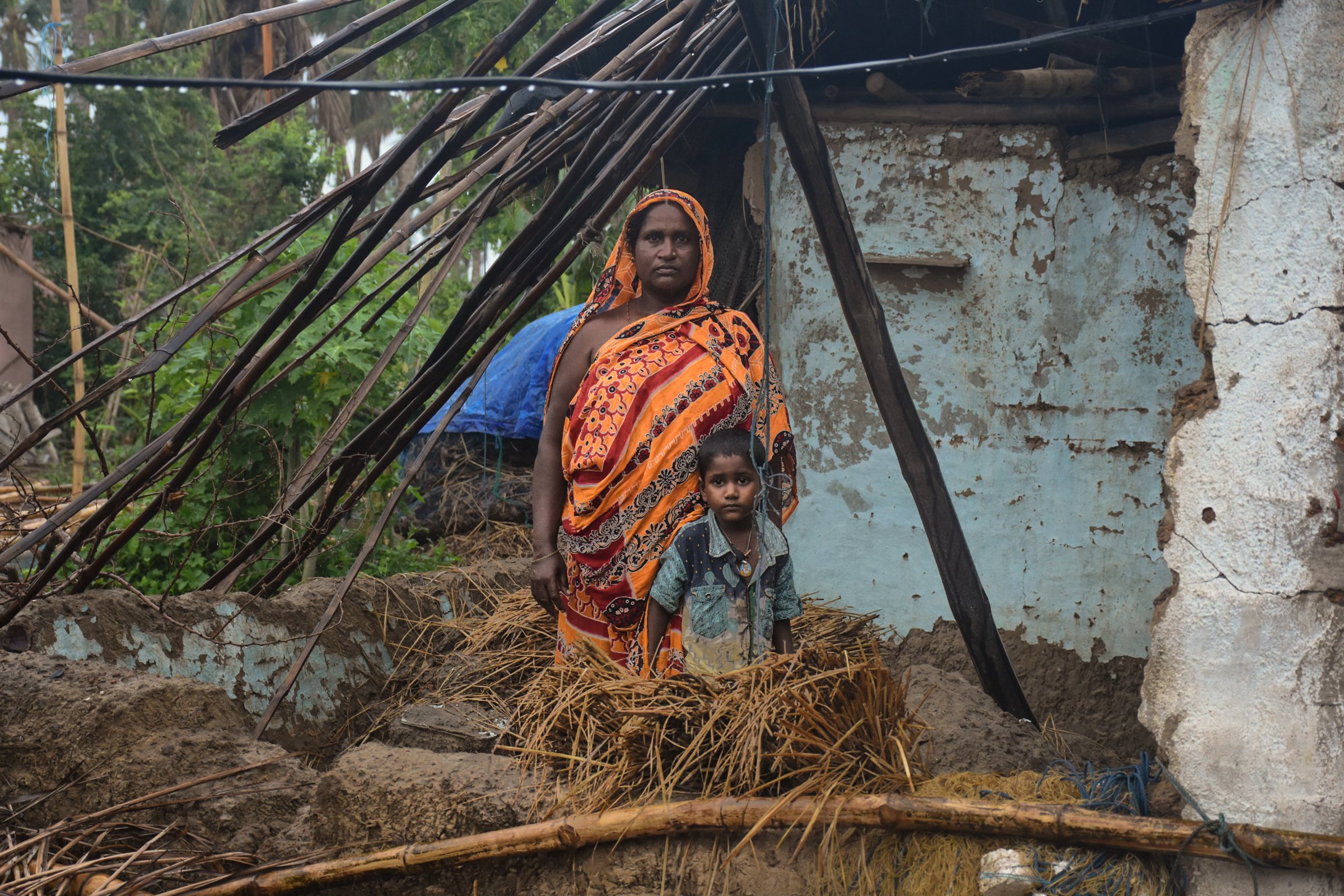 Photo of woman and child inside a cyclone-damaged home in India