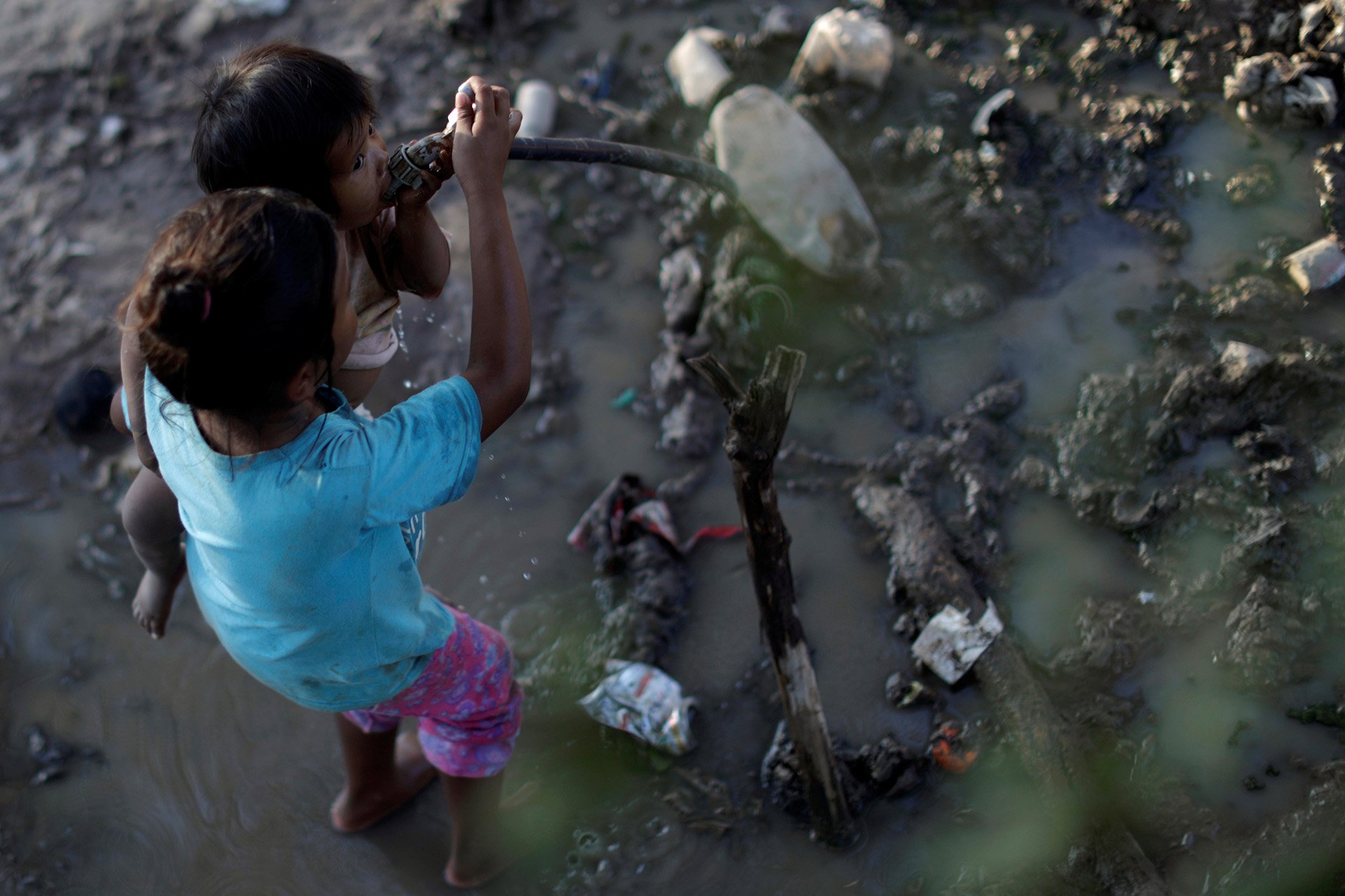 Children from the Indigenous Wichí community drink water from a faucet in Salta province, 28 February 2020.