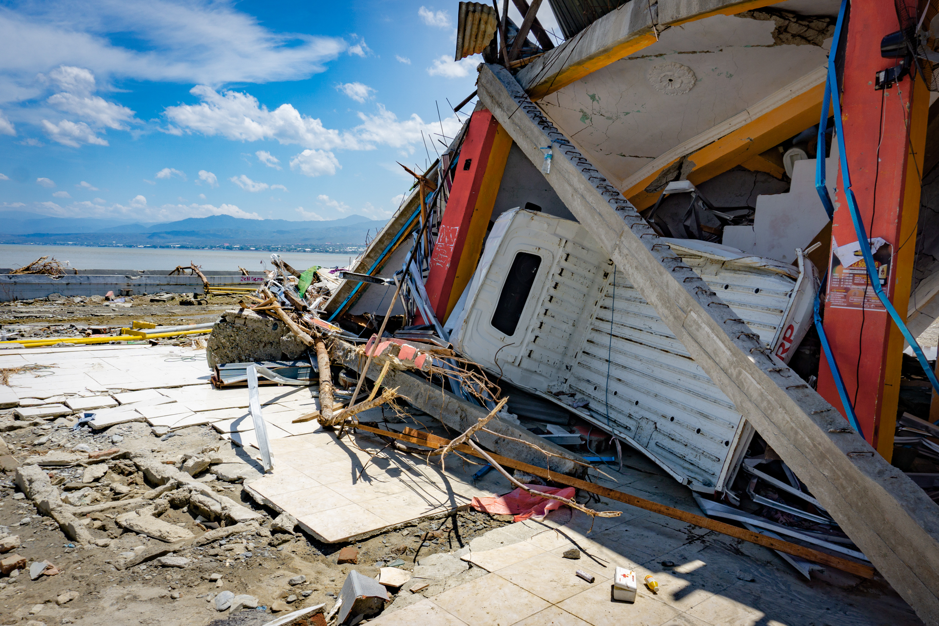 A truck is buried under the rubble of a collapsed building along the shoreline of Palu, the capital of Indonesia’s Central Sulawesi province.