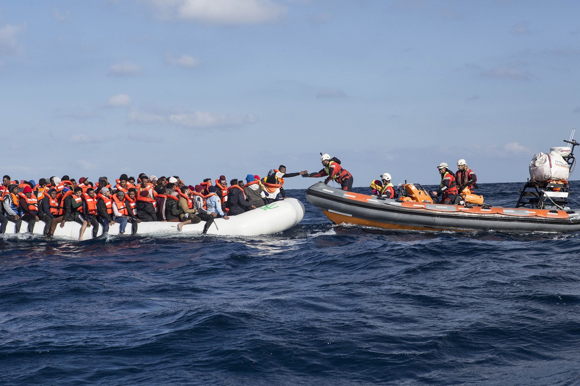 Image of a cultural mediator from Sea-Watch 3 stretching out his hand during a rescue