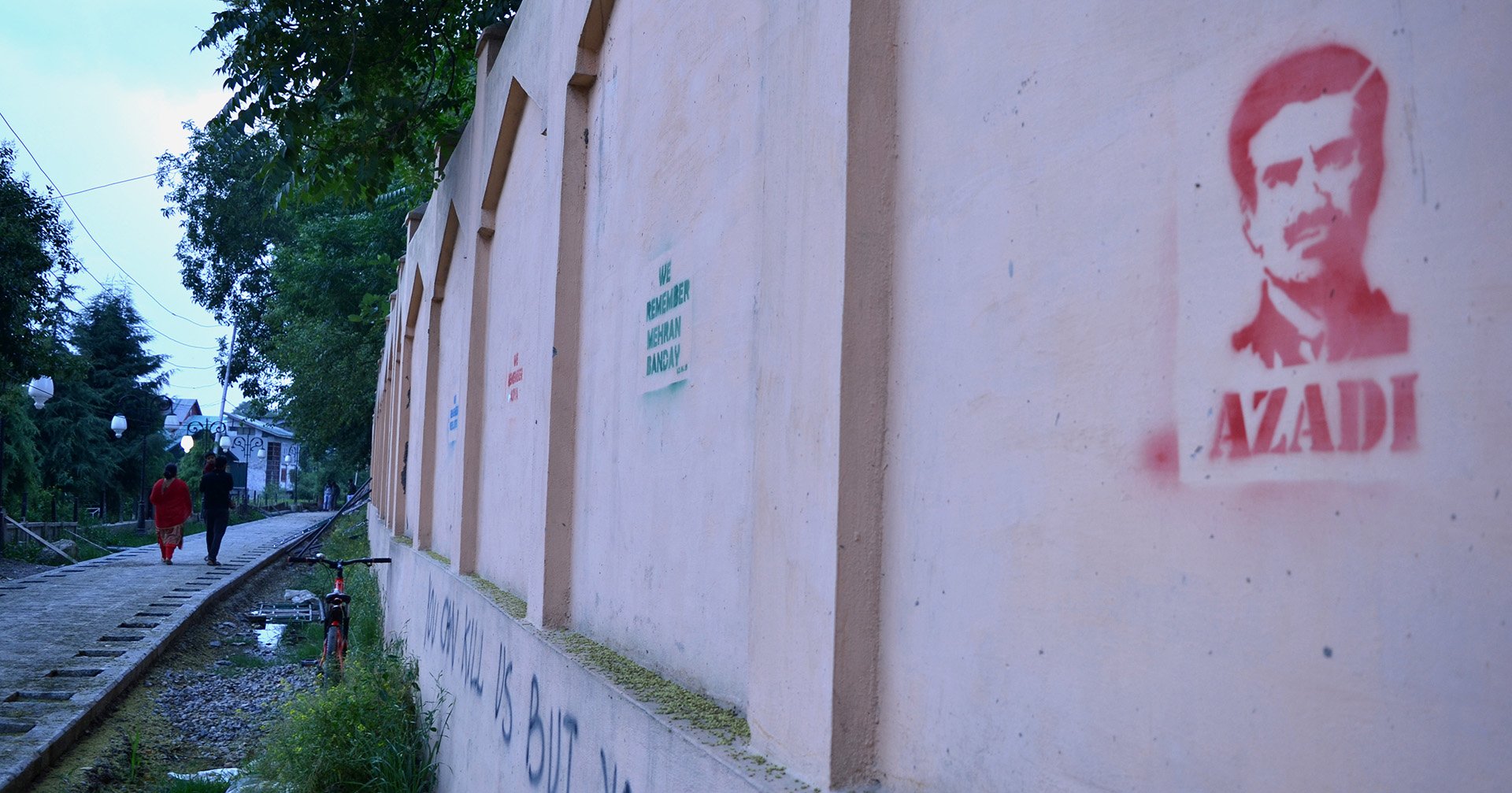 Protest graffiti lines a wall