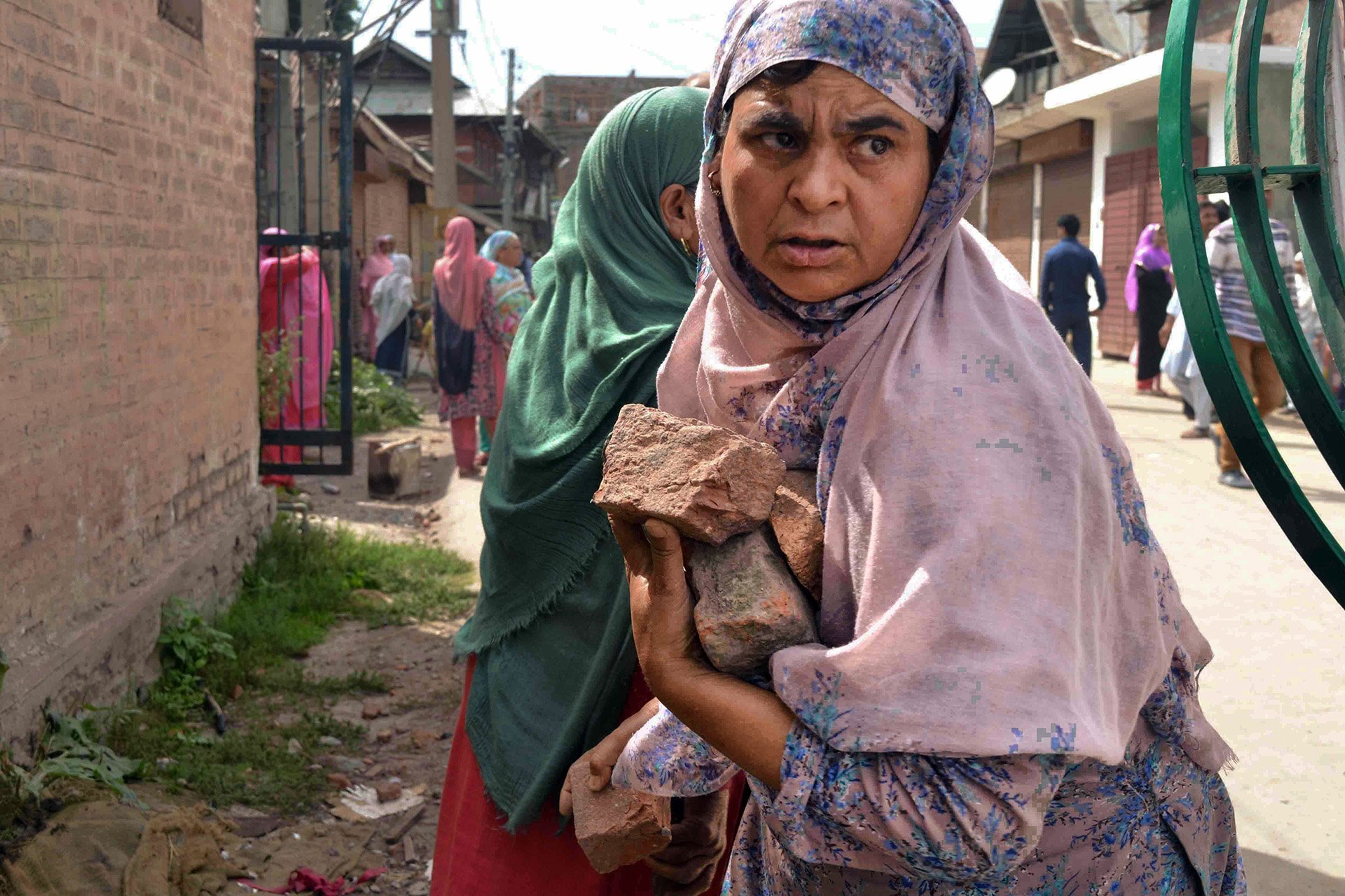 A woman in Srinagar carries stones during a demonstration