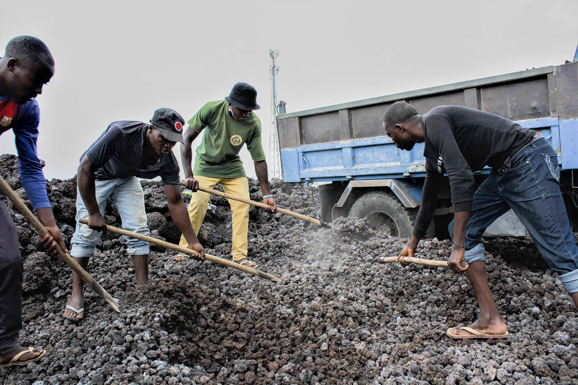 Men shovel gravel made from hardened lava rocks into trucks in Goma in the hope of earning a few dollars.