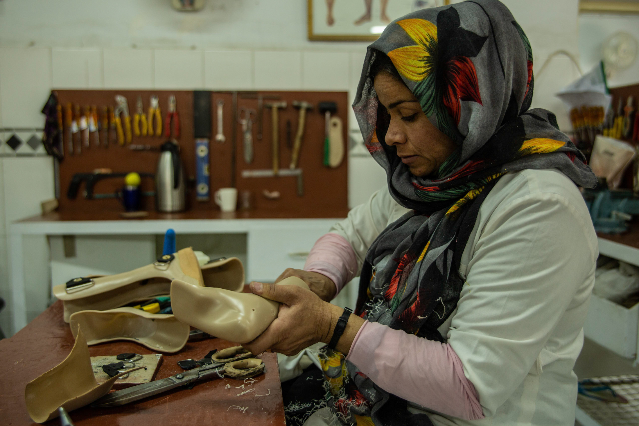 A woman works on a prosthetic limb.