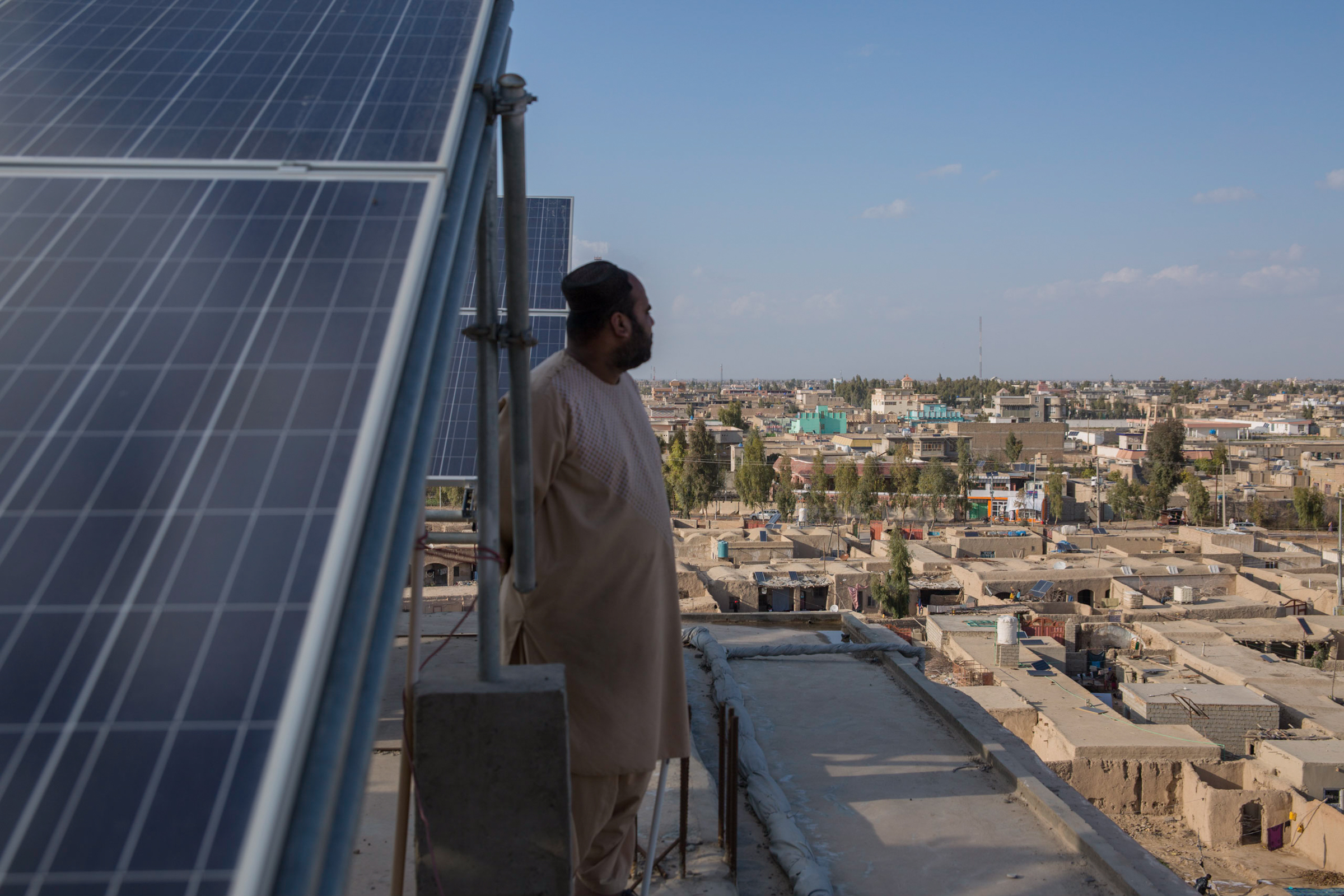 Photo of a man in Afghanistan on a roof with solar panels