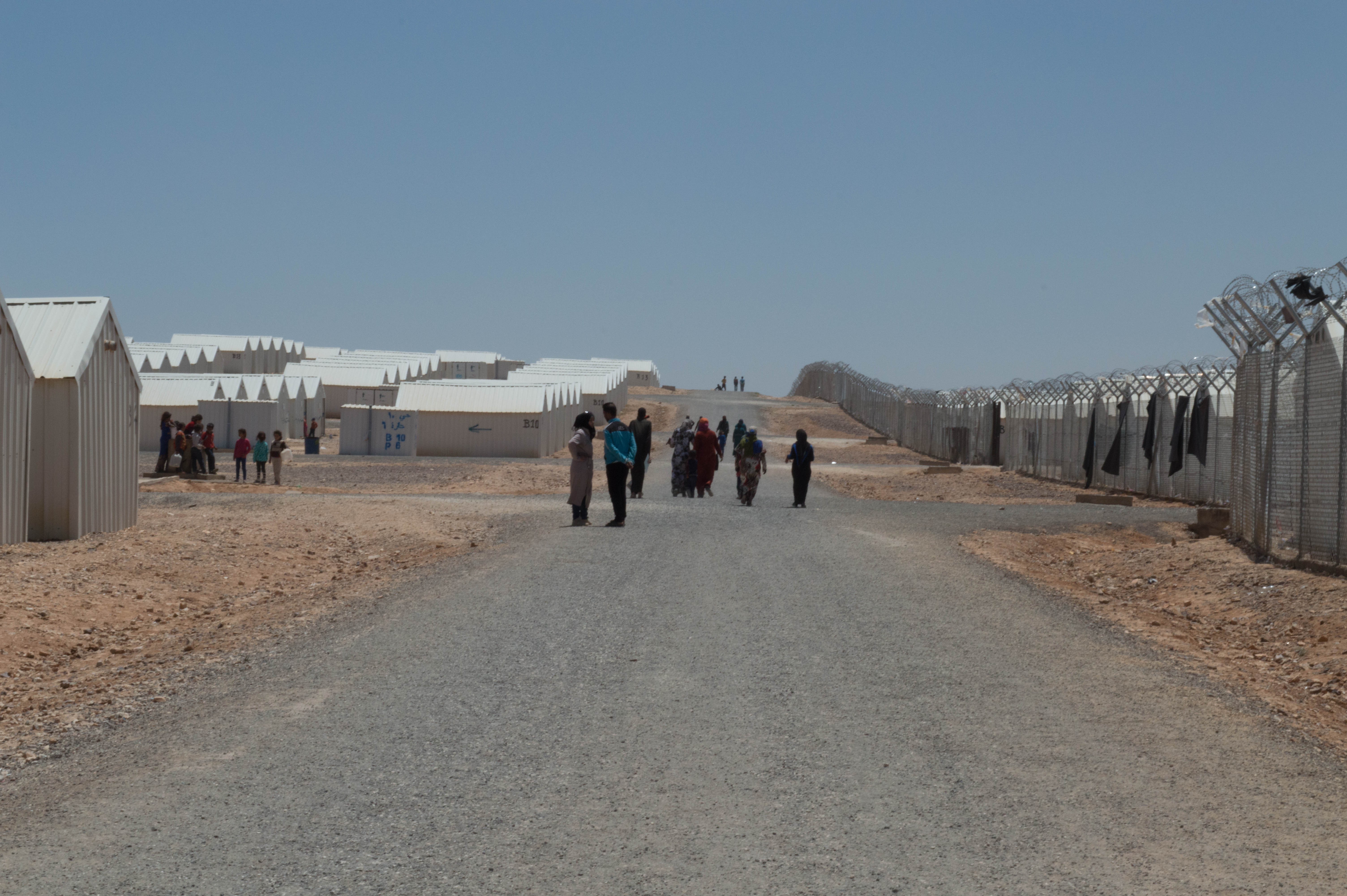 Barbed wire fence and white shelters