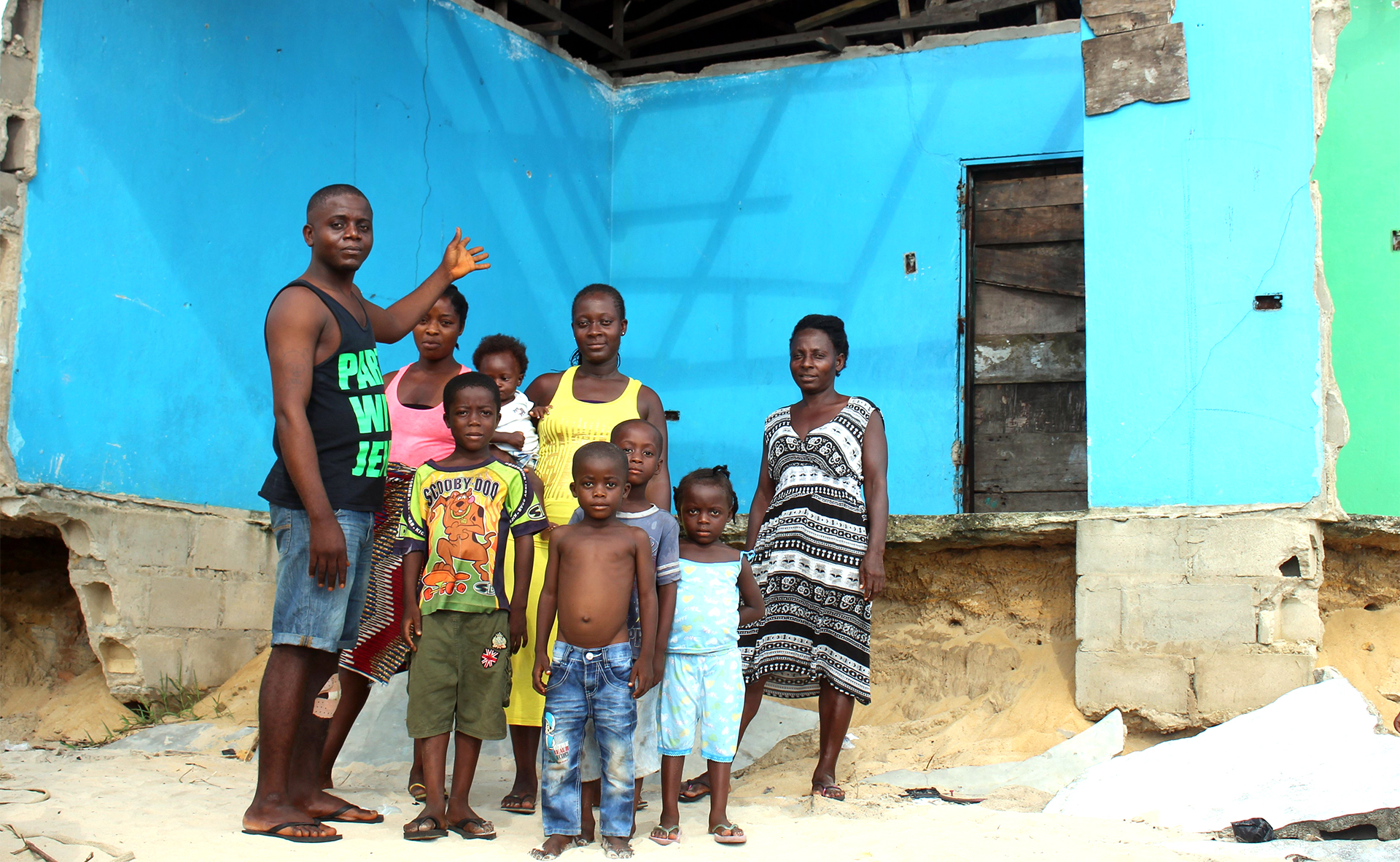 A family in front of a broken building