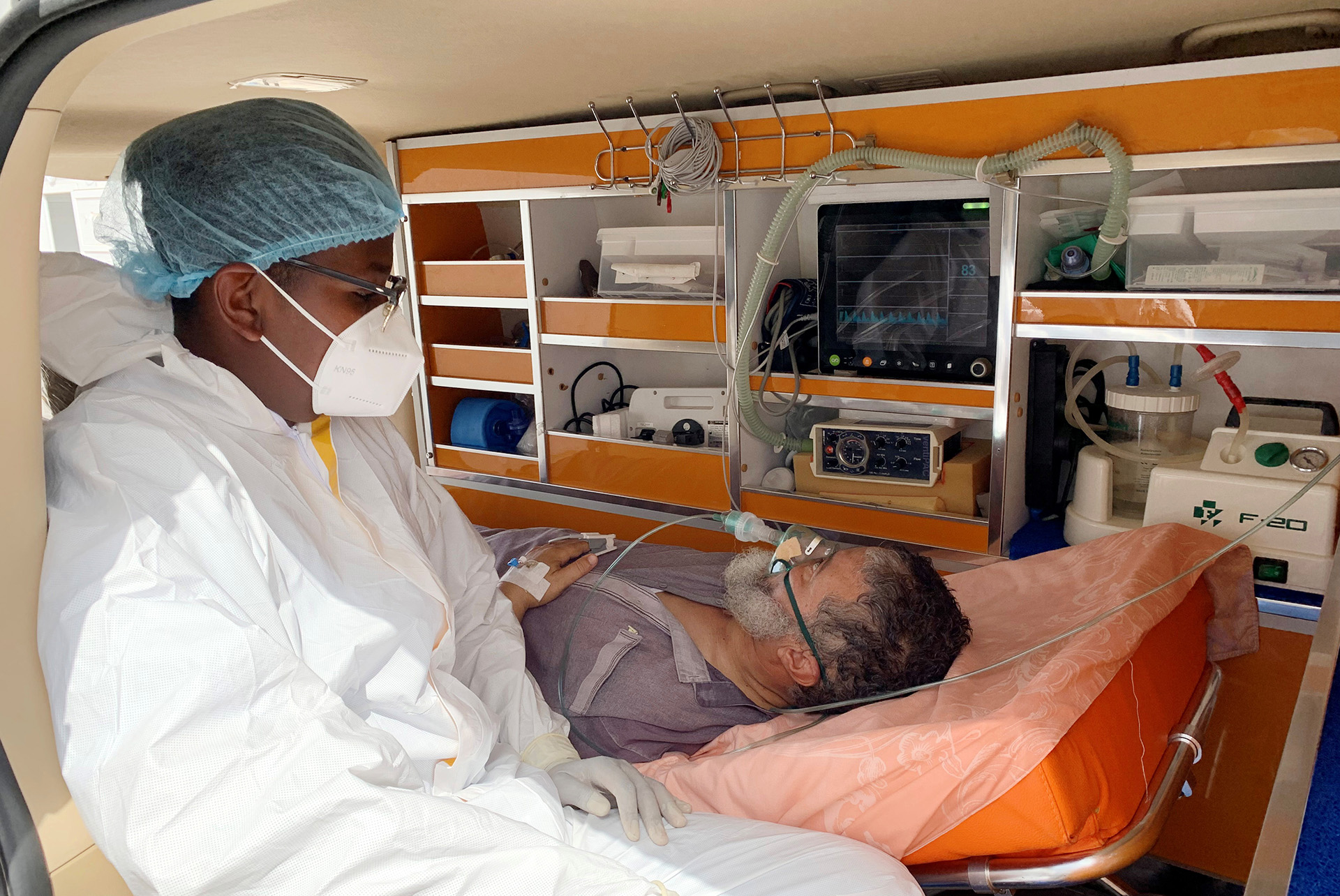 A nurse sits with a patient in an ambulance as he waits to be admitted to a COVID-19 ward in Misrata, northwestern Libya, on 13 July 2021.