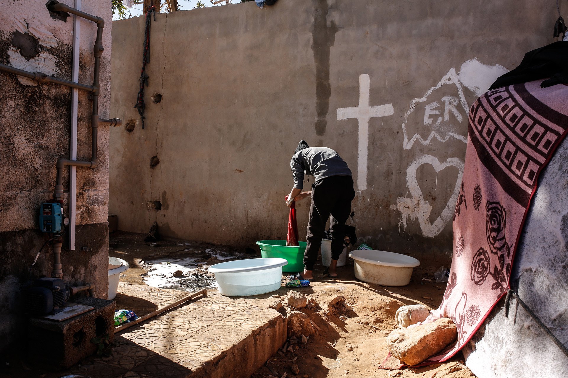 An asylum seeker washes clothes at the Dhar el-Jebel centre in Zintan on 15 December 2020. Detainees had been told by local authorities and UN agencies they would shortly be released and transferred to Tripoli, but the operation was repeatedly postponed.