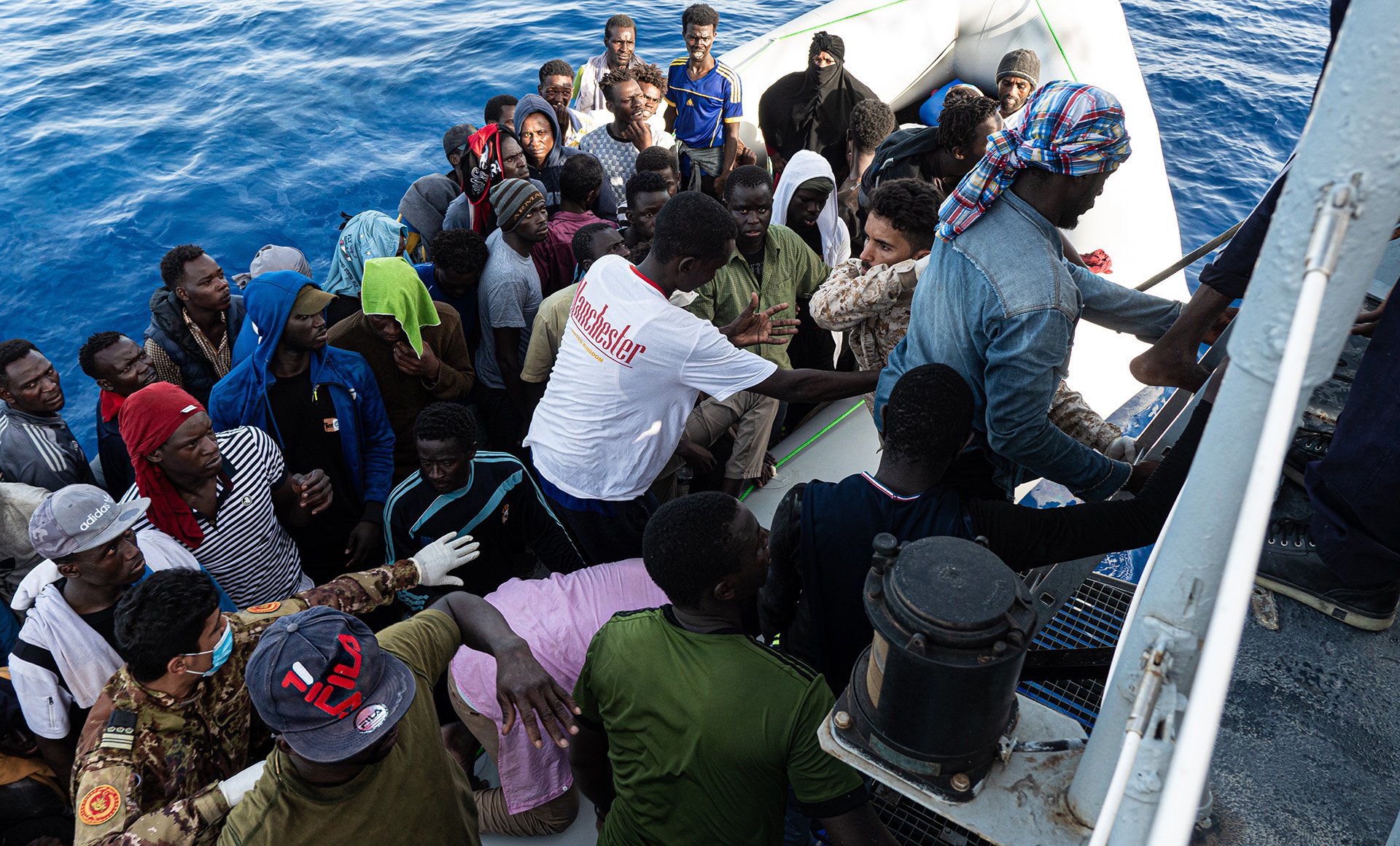 Libya Coast Guard boarding migrants onto a ship