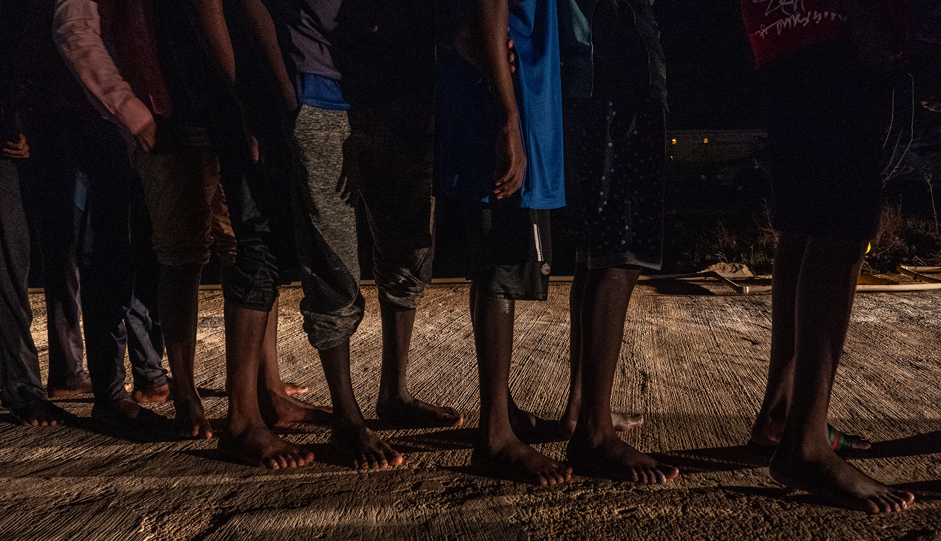 Migrants wait in line at Tripoli’s naval base